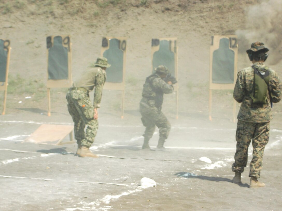 U.S. Marine Corps Staff Sgt. Daniel Monteiro (right) and U.S. Navy Master at Arms 2nd Class Steven Cabrera observe a member of Guatemala’s Fuerzas Especiales Naval execute a live-fire exercise during marksmanship training. The Security Cooperation Team trained members of the FEN in a variety of military classes, including human rights, first aid, small-unit leadership, and weapon-systems marksmanship. (Official Marine Corps photo: Courtesy//Released)