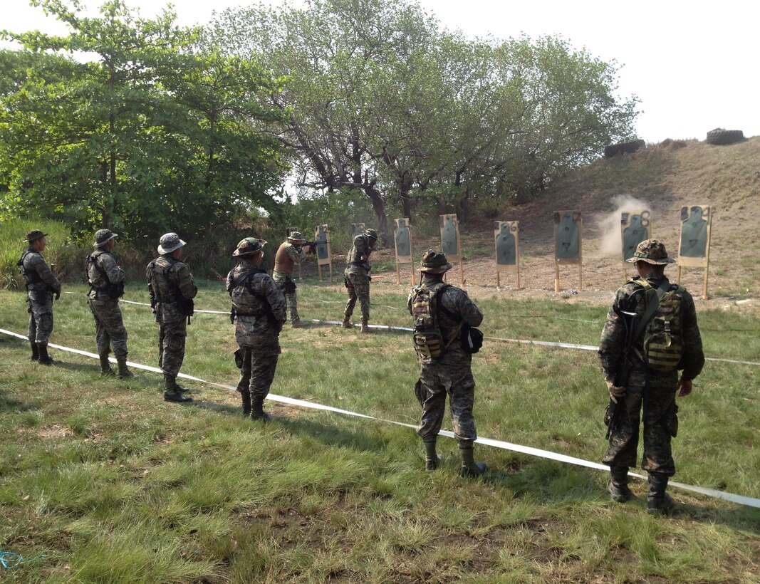 U.S. Marine Corps Staff Sgt. Richard Ekhaguere demonstrates to members of Guatemala’s Fuerzas Especiales Naval how to transition from firing with a rifle to firing with a pistol during marksmanship training.  The Security Cooperation Team trained members of the FEN in a variety of military classes , including human rights, first aid, small-unit leadership, and weapon-systems marksmanship. (Official Marine Corps photo: Courtesy//Released)