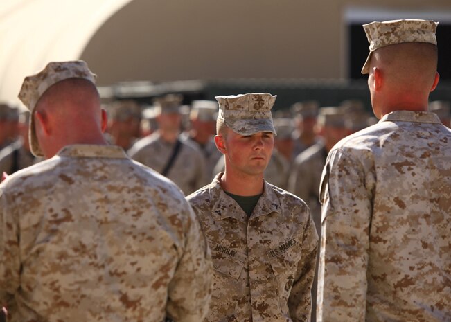 Lance Cpl. Joel T. Murray, a Hallsville, Texas, native and engineer heavy equipment operator with Combat Logistics Company, Combat Logistics Regiment 2, Regional Command (Southwest), stands before Maj. David H. Mills (right), company commander of Combat Logistics Company, CLR-2, during an awards ceremony at Camp Leatherneck, Afghanistan, July 23, 2013. Murray received the Navy and Marine Corps Commendation Medal with "V" device for heroic achievement during an insurgent attack on Forward Operating Base Shir Ghazi in Helmand province, May 13, 2013. (U.S. Marine Corps photo by Cpl. Paul Peterson)