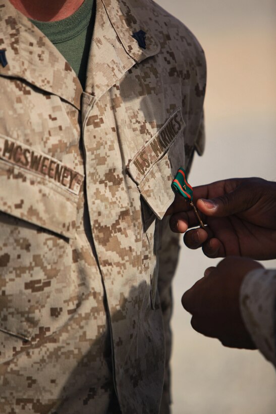 Cpl. Ryan T. McSweeney, a Middletown, Ohio, native and recovery vehicle operator with Transportation Support Company, Combat Logistics Regiment 2, Regional Command (Southwest), receives the Navy and Marine Corps Achievement Medal with Combat Distinguishing Device during an award ceremony at Camp Leatherneck, Afghanistan, July 23, 2013. McSweeney braved direct enemy fire while engaging insurgents during an attack on a forward operating base in Helmand province. 