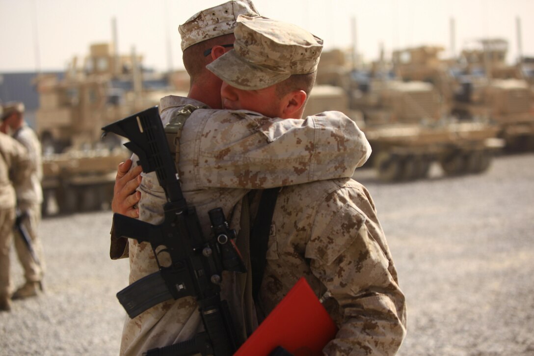 Cpl. Ryan T. McSweeney (right), a Middletown, Ohio, native and recovery vehicle operator with Transportation Support Company, Combat Logistics Regiment 2, Regional Command (Southwest), embraces a fellow Marine after receiving the Navy and Marine Corps Achievement Medal with Combat Distinguishing Device during an award ceremony at Camp Leatherneck, Afghanistan, July 23, 2013. McSweeney responded to the site of a suicide vehicle-borne improvised explosive device and helped repel an insurgent assault on Forward Operating Base Shir Ghazi in Helmand province.