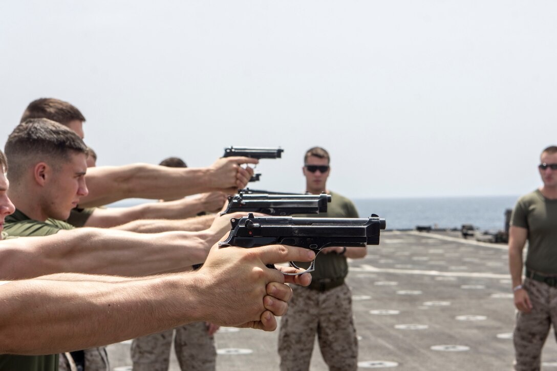 U.S. Marines assigned to Company K, Battalion Landing Team 3/2, 26th Marine Expeditionary Unit (MEU), practice pistol marksmanship skills with unloaded M9 pistols on the flight deck of the USS Carter Hall (LSD 50), at sea, July 24, 2013. The 26th MEU is a Marine Air-Ground Task Force forward-deployed to the U.S. 5th Fleet area of responsibility aboard the Kearsarge Amphibious Ready Group serving as a sea-based, expeditionary crisis response force capable of conducting amphibious operations across the full range of military operations. (U.S. Marine Corps photo by Cpl. Michael S. Lockett/Released)