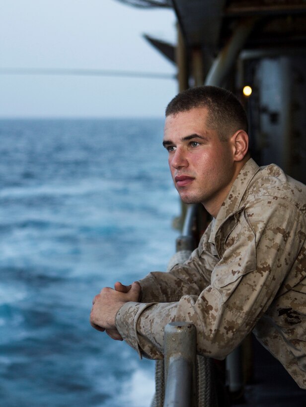 U.S. Marine Corps Lance Cpl. Brandon Carteaux, an amphibious assault vehicle crewman assigned to Battalion Landing Team 3/2, 26th Marine Expeditionary Unit (MEU), looks over the side of the USS Carter Hall (LSD 50), at sea, July 24, 2013. The 26th MEU is a Marine Air-Ground Task Force forward-deployed to the U.S. 5th Fleet area of responsibility aboard the Kearsarge Amphibious Ready Group serving as a sea-based, expeditionary crisis response force capable of conducting amphibious operations across the full range of military operations. (U.S. Marine Corps photo by Cpl. Michael S. Lockett/Released)