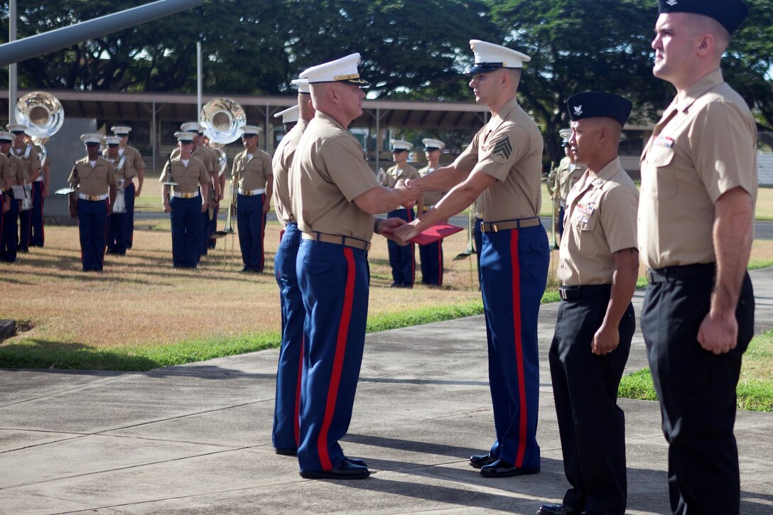 Col. Brian P. Annichiarico, commanding officer, Marine Corps Base Hawaii, and Sgt. Maj. Robert E. Eriksson, sergeant major, MCB Hawaii, present Marines and sailors with personal awards during the quarterly morning colors ceremony at the base flagpole, July 19, 2013. (U.S. Marine Corps photo by Lance Cpl. Suzanna Knotts)
