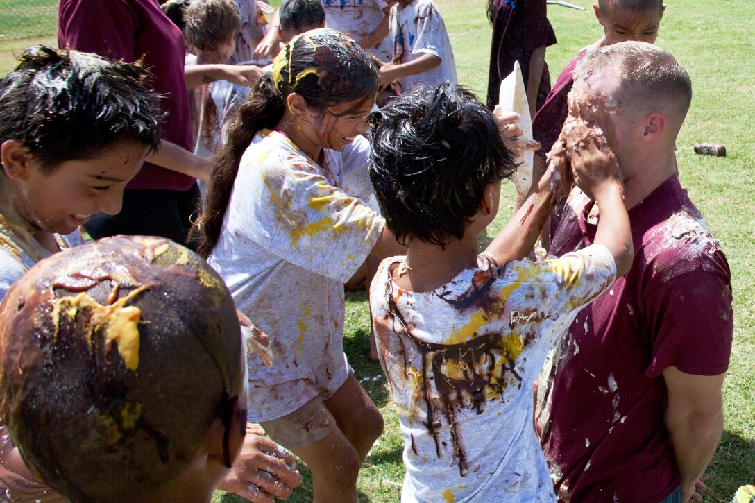 Cpl. Luke Johnson, 25, a patrolman for the Provost Marshal’s Office gets a special pie in the face, filled with assorted ingredients after a Drug Education for Youth program activity at the PMO Field, July 23, 2013. Each participant either was blindfolded or led a blindfolded partner through an obstacle course, while their peers distracted them in various ways. Johnson, a native of St. Augustine, Fla., is currently volunteering as a mentor for the DEFY program.(U.S. Marine Corps photo by Lance Cpl. Nathan Knapke) 