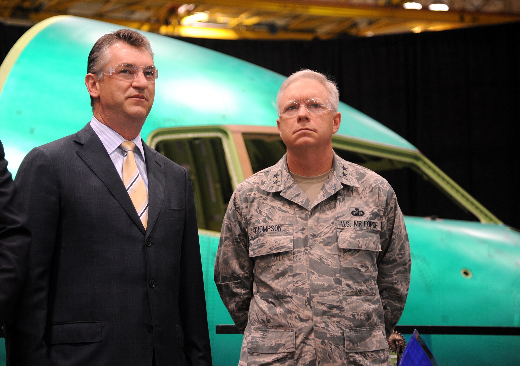 Maj. Gen. John F. Thompson, U.S. Air Force program executive officer for tankers, and Larry Lawson, Spirit AeroSystems president and CEO, stand in front of the cockpit of a KC-46A as the forward fuselage rollout begins July 26, 2013, in Wichita, Kan. One hundred and seventy-nine KC-46As will replace the aging KC-135 Stratotanker fleet at a one-to-one ratio. (U.S. Air Force photo/Airman 1st Class John Linzmeier)