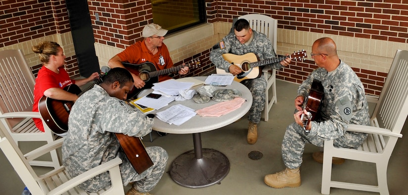 Soldiers with the Warrior Transition Unit practice guitar during their lesson as part of the “Music for Morale” program at Fort Eustis, Va., July 11, 2013. The program is available to all WTU Soldiers, regardless of guitar-playing experience. (U.S. Air Force photo by Staff Sgt. Wesley Farnsworth/Released)