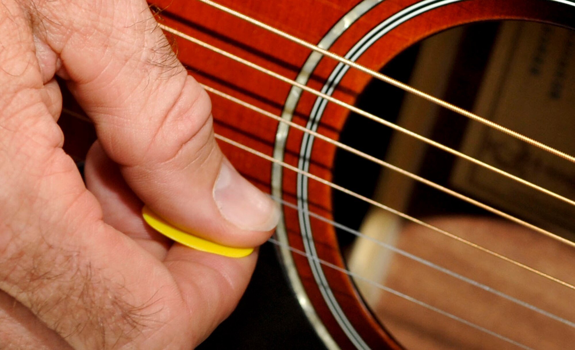 Woody Groton, Warrior Transition Unit site coordinator for the military adaptive sport program, tunes his guitar before starting guitar lessons at Fort Eustis, Va., July 11, 2013. Groton teaches Soldiers within the WTU how to play guitar as part of their healing program. (U.S. Air Force photo by Staff Sgt. Wesley Farnsworth/Released)  