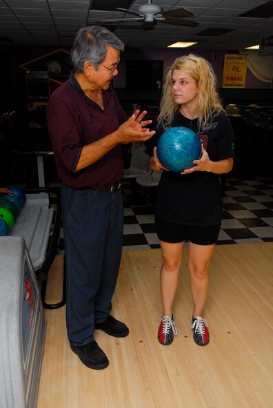 Clyde Higa, United States Bowling Congress bronze level coach, instructs Heather Tugung, spouse of Ulbert Tugung, 56th Logistics Readiness Squadron, on bowling technique July 20 during the hook-up-to-bowling event at Thunderbolt Lanes. Higa coached participants on bowling fundamentals such as how to select the correct bowling ball, the approach, where to aim and how to properly throw the ball down the lane. (U.S. Air Force photo/Senior Airman David Owsianka)