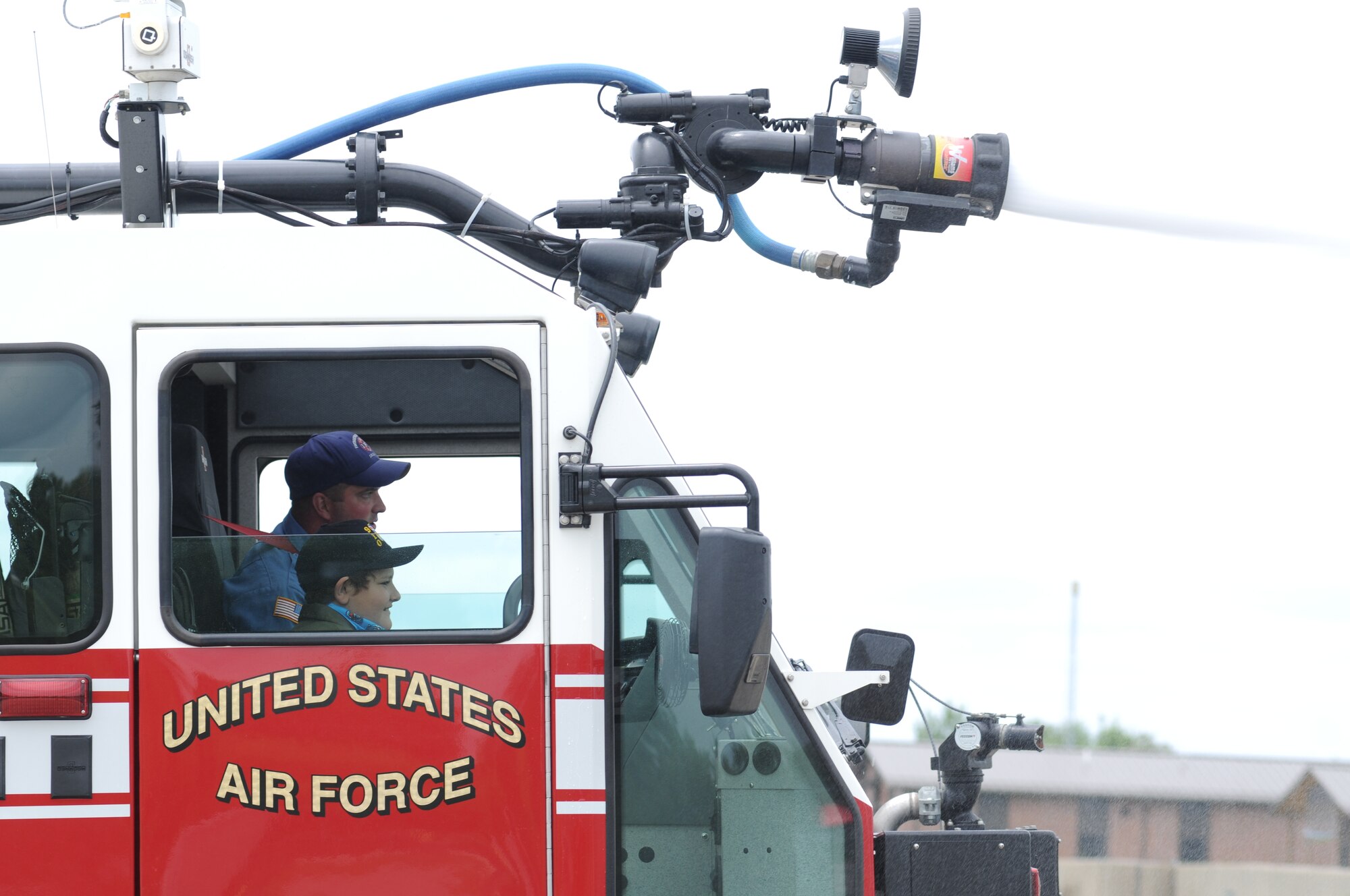 YOUNGSTOWN AIR RESERVE STATION, Ohio -- The 910th Airlift Wing's 54th Pilot for a Day, honorary 2nd Lieutenant Nicholas Greathouse, sprays water from a station fire truck with the help of base firefighters, here, July 24. Pilot for a Day is a community outreach program that works through Akron Children's Hospital Boardman to welcome children with chronic or life-threatening illnesses to the station for a day of military experiences. U.S. Air Force photo by TSgt. Jim Brock.