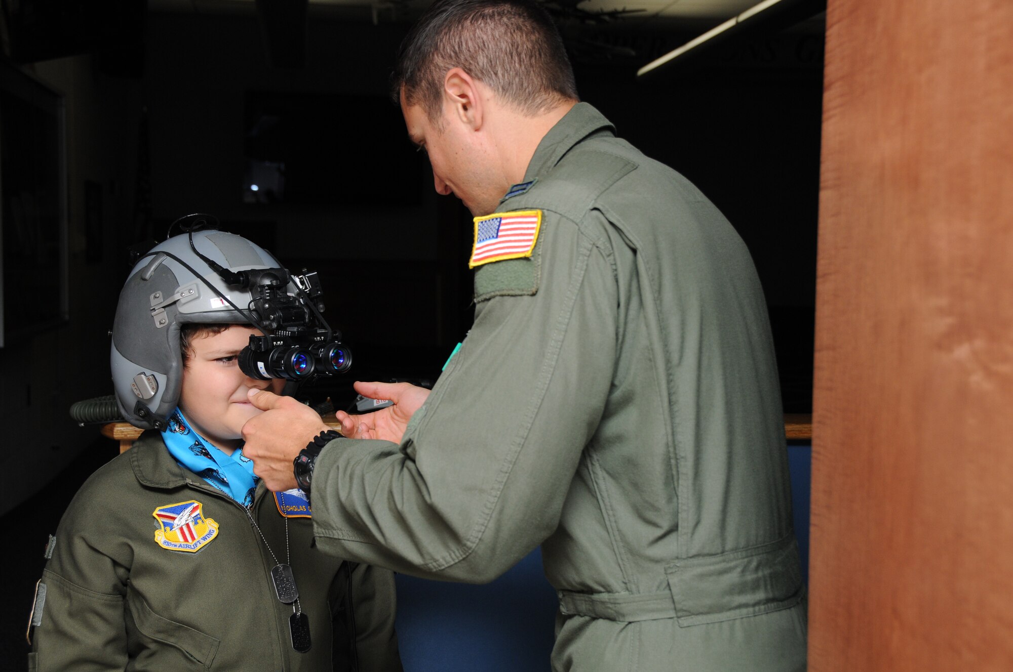 YOUNGSTOWN AIR RESERVE STATION, Ohio -- The 910th Airlift Wing's 54th Pilot for a Day, honorary 2nd Lieutenant Nicholas Greathouse, tries on night vision goggles with the assistance of Air Force Reserve Capt. Adam Schubel, a pilot with the 773rd Airlift Squadron, here, July 24. Pilot for a Day is a community outreach program that works through Akron Children's Hospital Boardman to welcome children with chronic or life-threatening illnesses to the station for a day of military experiences. U.S. Air Force photo by SrA Rachel Kocin.