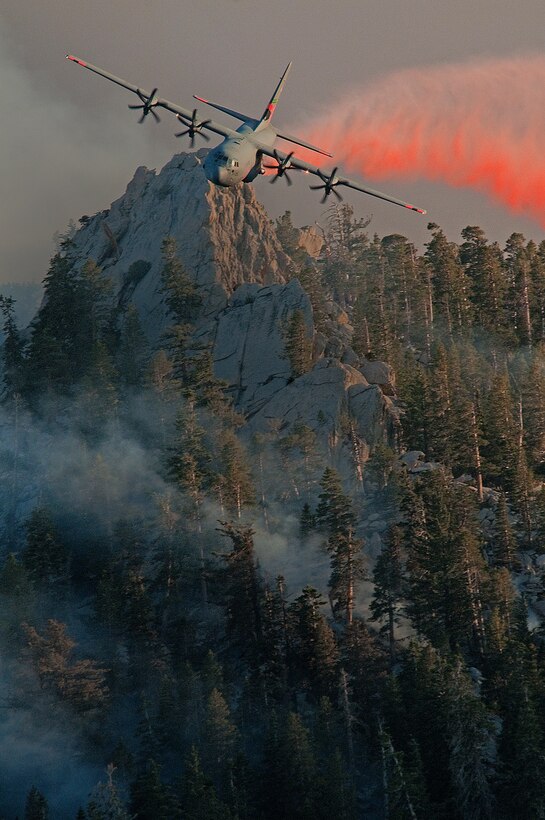 A C-130 Hercules aircraft releases fire retardant over the trees in the mountains above Palm Springs, Calif., July 19, 2013. The unit was activated to assist the community with wildfires. The C-130 Hercules is assigned to the 146th Airlift Wing, California Air National Guard. (U.S. Air National Guard photo/Senior Airman Nicholas Carzis)
