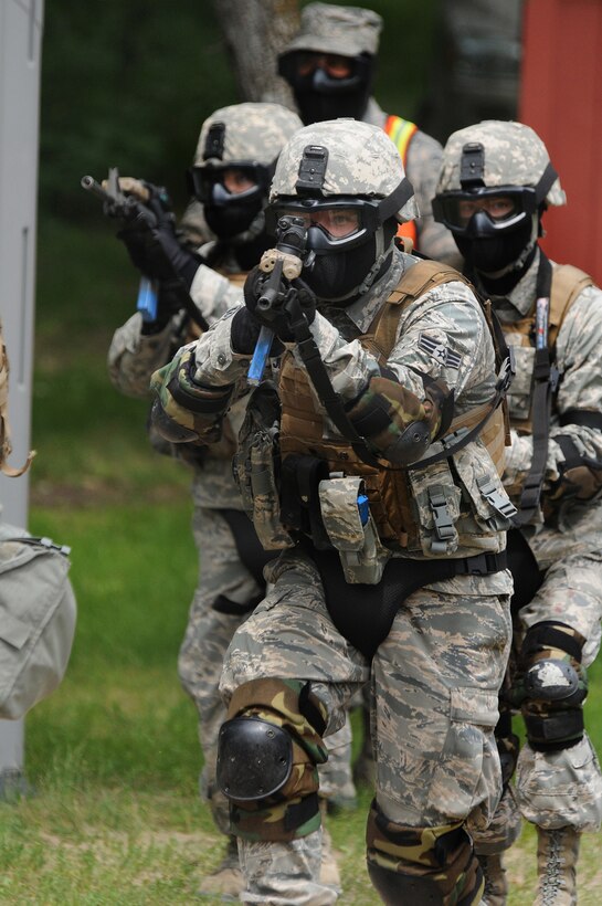 Senior Airman Cody Jenson leads a simulated attack on a training building in an effort to clear the building of hostile forces during combat training July 17, 2013, in the Military Operations in Urban Terrain village at Camp Grafton, N.D. The personnel are wearing protective gear because they are firing simunition rounds that are similar to paintball rounds. Jenson is assigned to the 219th Security Forces Squadron, N.D. Air National Guard. (U.S. Air National Guard photo/Senior Master Sgt. David H. Lipp)