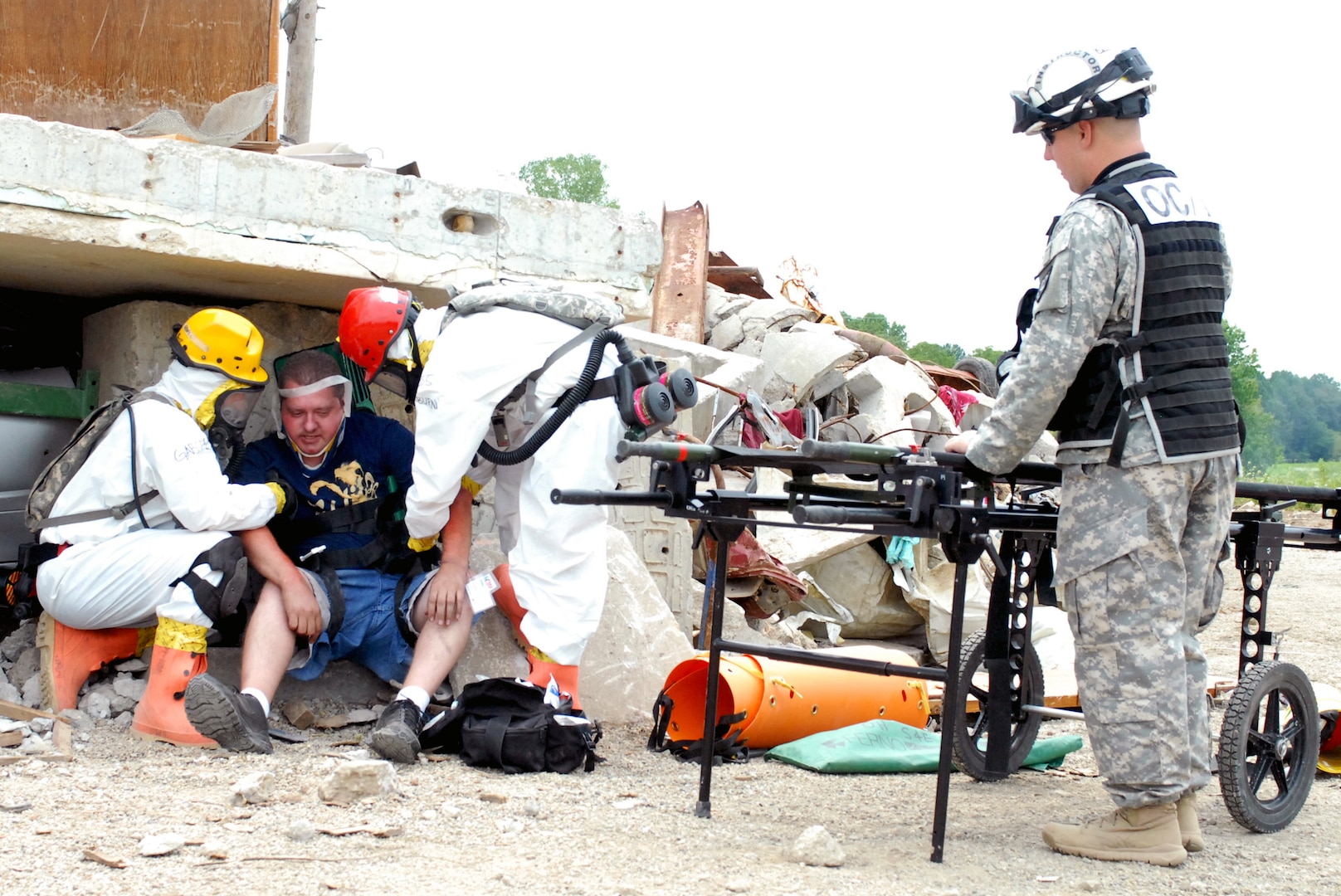 Sgt. Seth Light (right), an observer controller trainer assigned to 821st Engineer Company out of West Virginia, looks on as Sgt. Alex Gaboric, a military policeman from the 811th Engineer Company, an Ohio National Guard unit out of Tarlton, and Tech. Sgt. Ashley Blackburn, an airman and combat medic assigned to the 811th, treat a survivor of a simulated nuclear blast attack during last year’s Vibrant Response 13 field training exercise at the Muscatatuck Urban Training Center, Ind. (Photo by Sgt. Terence Ewings)