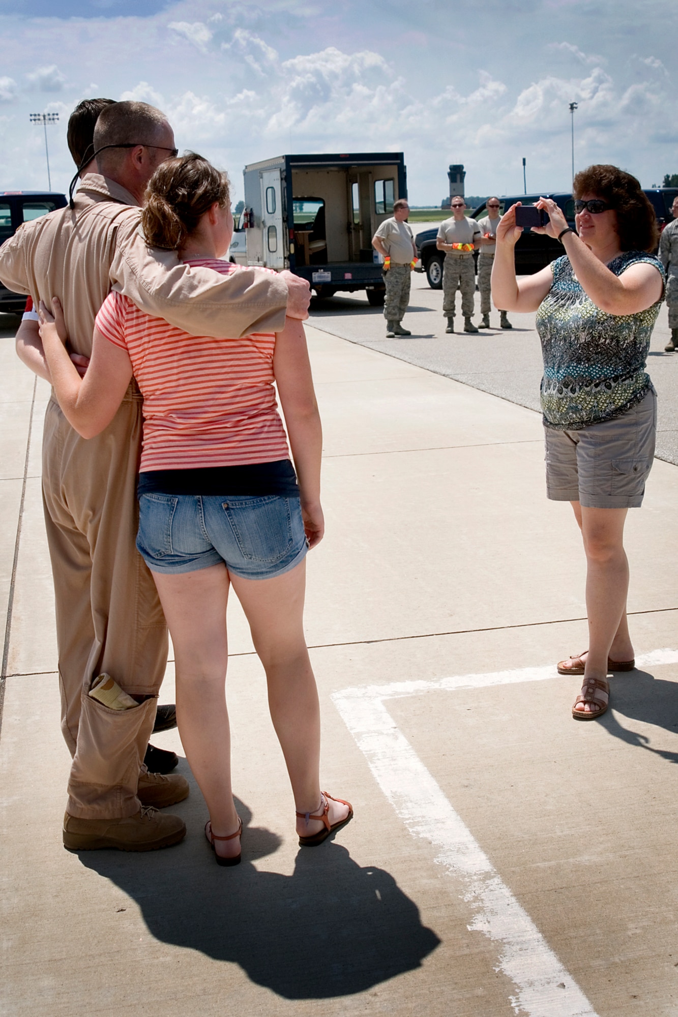 Dawn Thibault, wife of Lt. Col. Todd Thibault, 434th Operations Squadron chief of scheduling, takes a photo of him with their son Michael and daughter Mackenzie after landing at Grissom Air Reserve Base, Ind., July 21, 2013. Thibault and other aircrew members returned to Grissom that day following a deployment to Southwest Asia. (U.S. Air Force photo/Tech. Sgt. Douglas Hays)