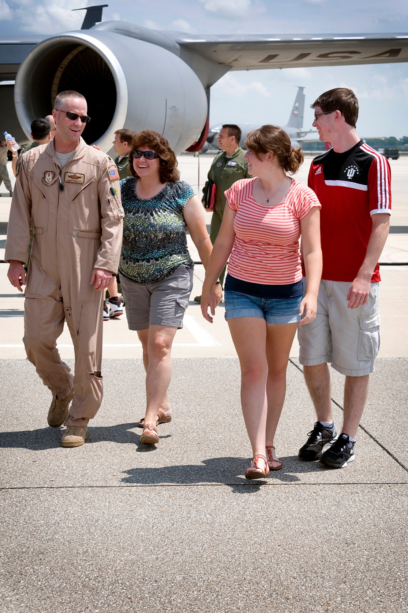 Lt. Col. Todd Thibault, 434th Operations Support Squadron chief of scheduling, walks with his family to the bus after landing at Grissom Air Reserve Base, Ind., July 21, 2013. Thibault is greeted by his wife Krystal, son Michael and daughter Mackenzie. He and other aircrew members returned to Grissom following a deployment to Southwest Asia. (U.S. Air Force photo/Tech. Sgt. Douglas Hays)