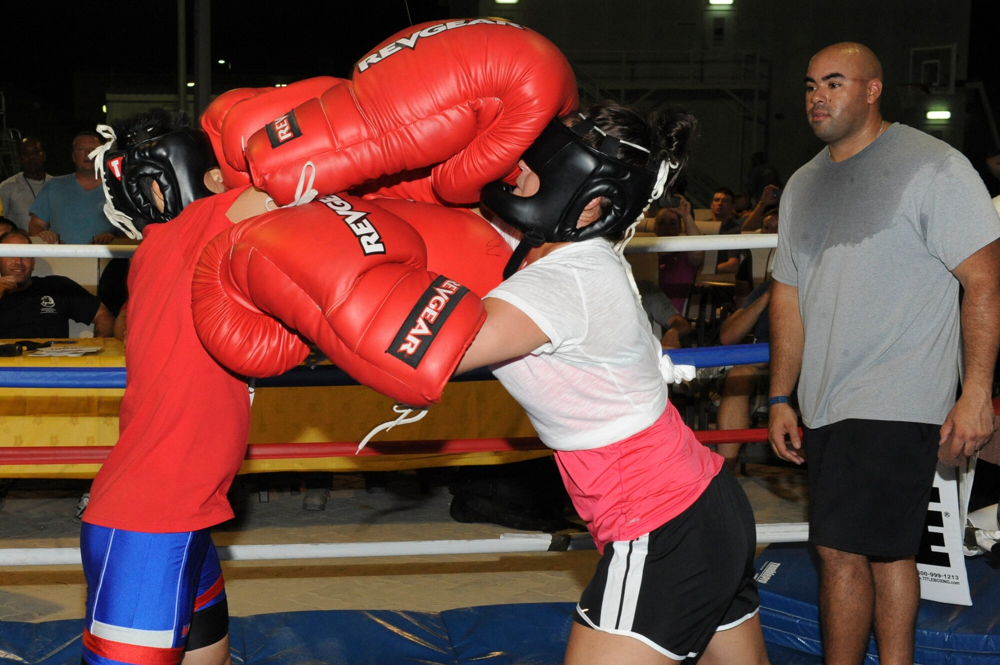 U.S. Air Force Airman Itzel Barrera-Rodriguez, 380th Expeditionary Security Forces Squadron, hits U.S. Air Force Senior Airman Laura Stevenson, 380th ESFS at the same time she was hit during a big glove boxing match at an undisclosed location in Southwest Asia July 19, 2013. Barrera-Rodriguez and Stevenson's fight was the main event for evening. Barrera-Rodriguez is deployed from Luke Air Force Base, Ariz., and Stevenson is deployed from Barksdale Air Force Base, La. (U.S. Air Force photo by Staff Sgt. Joshua J. Garcia)