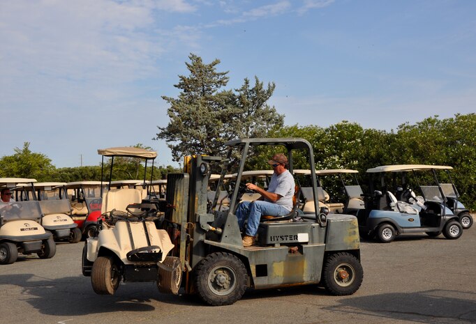 A Coyote Run Golf Course worker lifts away an old golf cart to make room for the incoming fleet of 76 new golf carts on Jul 23, 2013 at Beale Air Force Base, Calif. The new carts provide a series of benefits to its customers to include increased total revenue, more reliable, top of the line equipment, and an expedited golfing experience. (U.S. Air Force photo by 2nd Lt Siobhan Bennett)