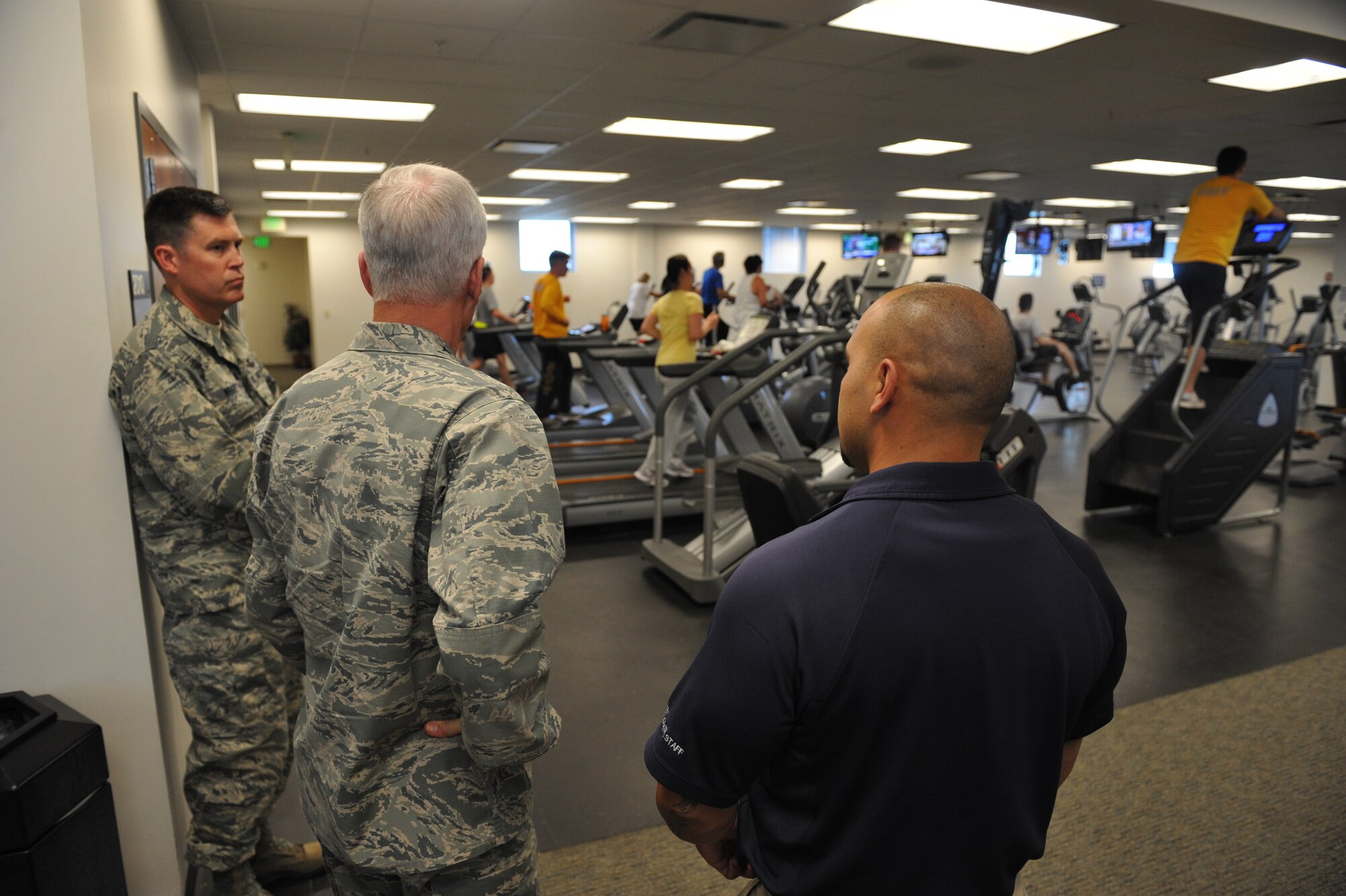 Bobby Padia, fitness center director, right, briefs, Gen. William Shelton, Air Force Space Command commander, and Col. Dan Wright, 460th Space Wing commander, during a tour of the facility July 23, on Buckley Air Force Base, Colo. The fitness center offers a variety of classes and programs to Airmen, their families and other eligible guests. (U.S. Air Force photo by Airman 1st Class Riley Johnson/Released)
