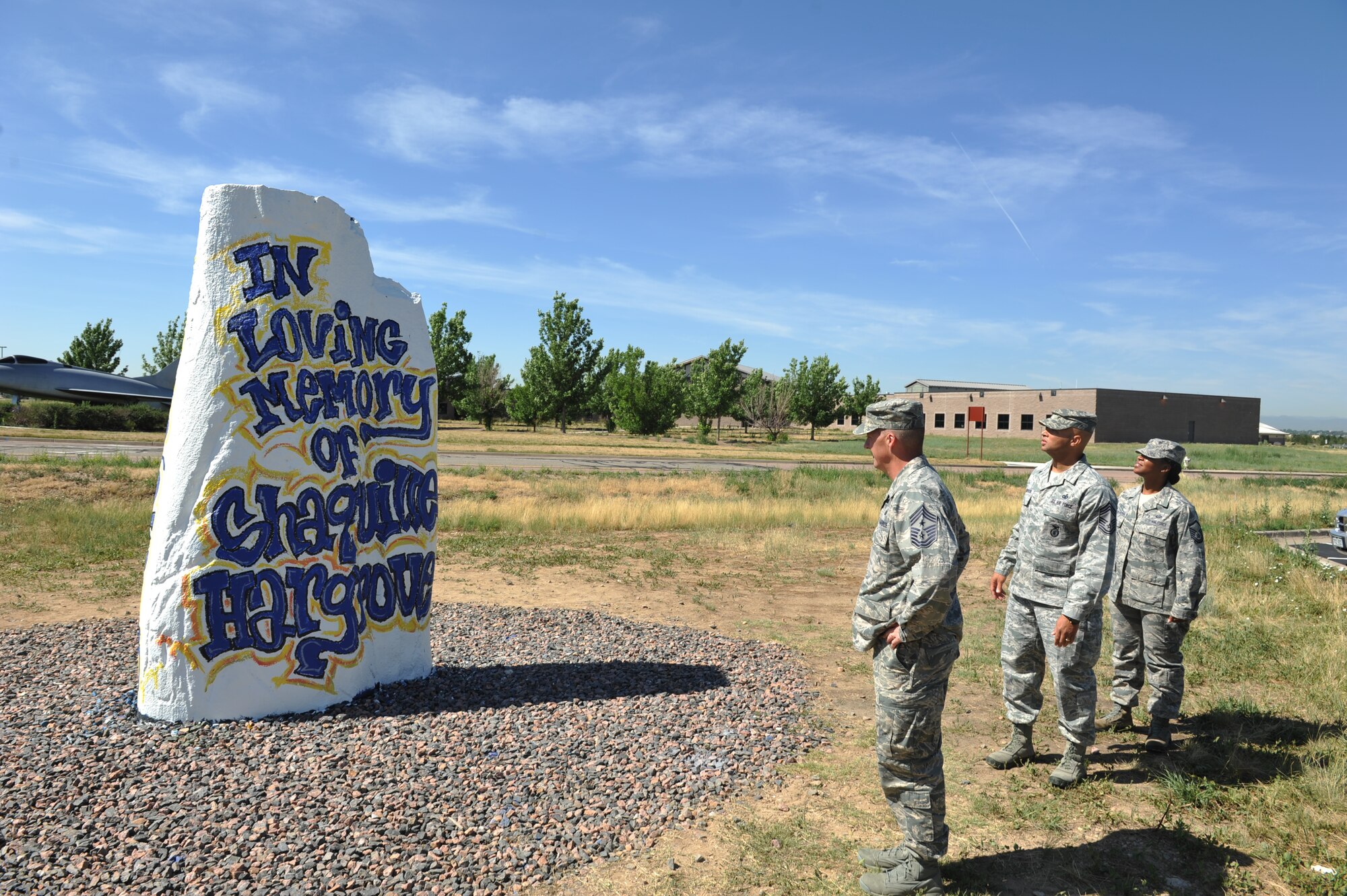 Chief Master Sgt. Douglas McIntyre, Air Force Space Command command chief, left, visits the Spirit Rock with Chief Master Sgt. Ben Roberson, 460th Mission Support Group chief enlisted manager, and Master Sgt. Pourshia Chambers-Motley, 460th MSG first sergeant, July 23, 2013, on Buckley Air Force Base, Colo. The visit was McIntyre’s first as the AFSPC command chief. (U.S. Air Force photo by Airman 1st Class Riley Johnson/Released)