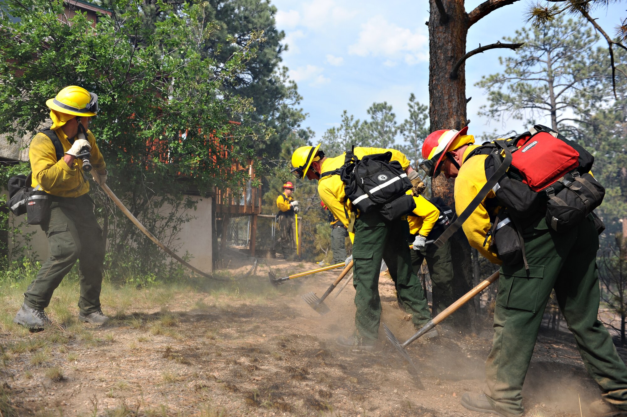 Air Force Academy firefighters dig a firebreak in the backyard of Jeff and Elizabeth Miller's home during the Black Forest Fire June 13, 2013. Although much of the Millers' five acres were burned, firefighters' timely response prevented the house from joining more than 500 others that the fire destroyed. (U.S. Air Force photo/Master Sgt. Christopher DeWitt)