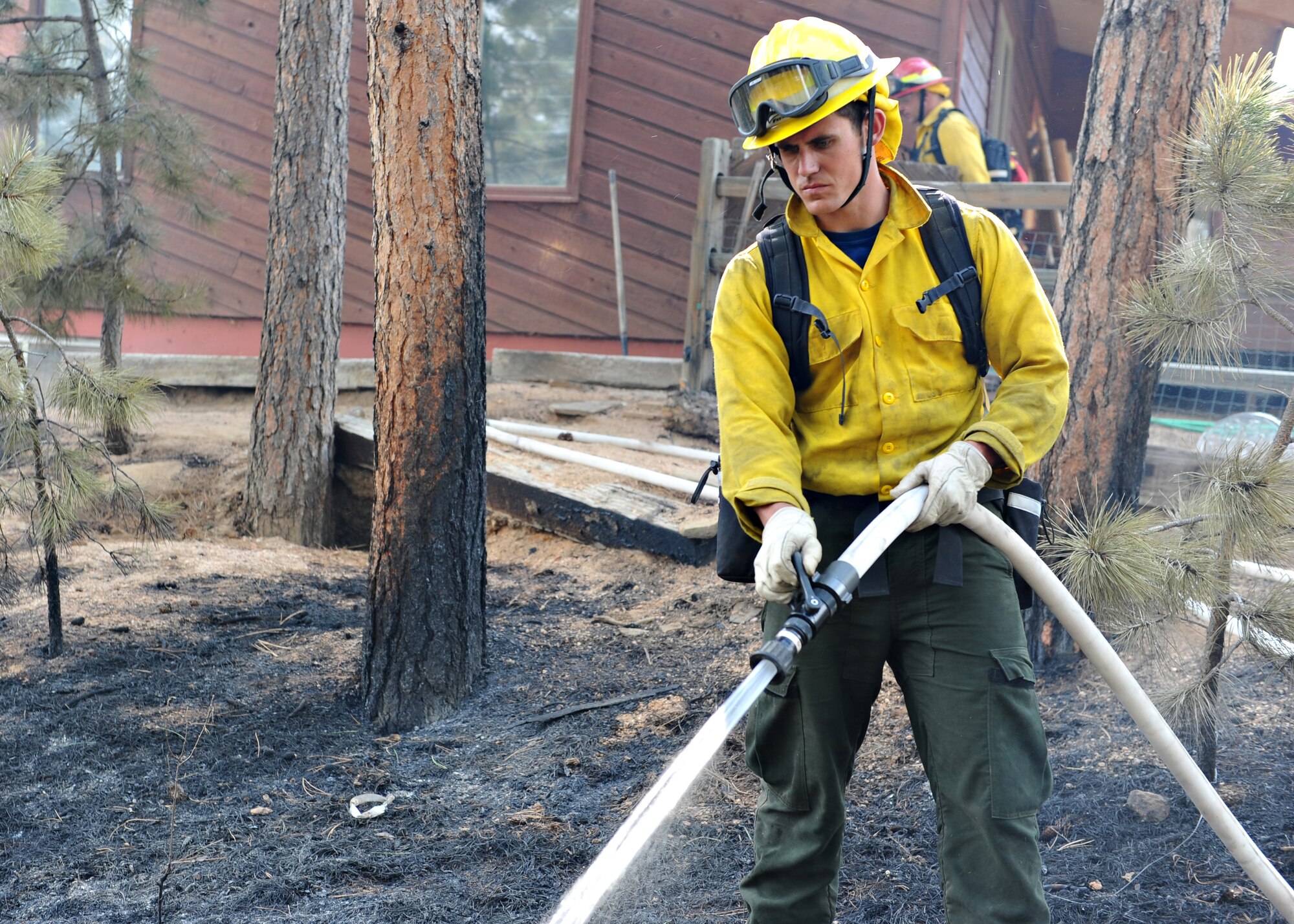 Air Force Academy firefighters work to protect the home of Jeff and Elizabeth Miller while fighting the Black Forest Fire north of Colorado Springs, Colo., June 13, 2013. The fire burned most of the Millers' five-acre property, but Academy firefighters prevented it from damaging the home. (U.S. Air Force photo/Master Sgt. Christopher DeWitt)