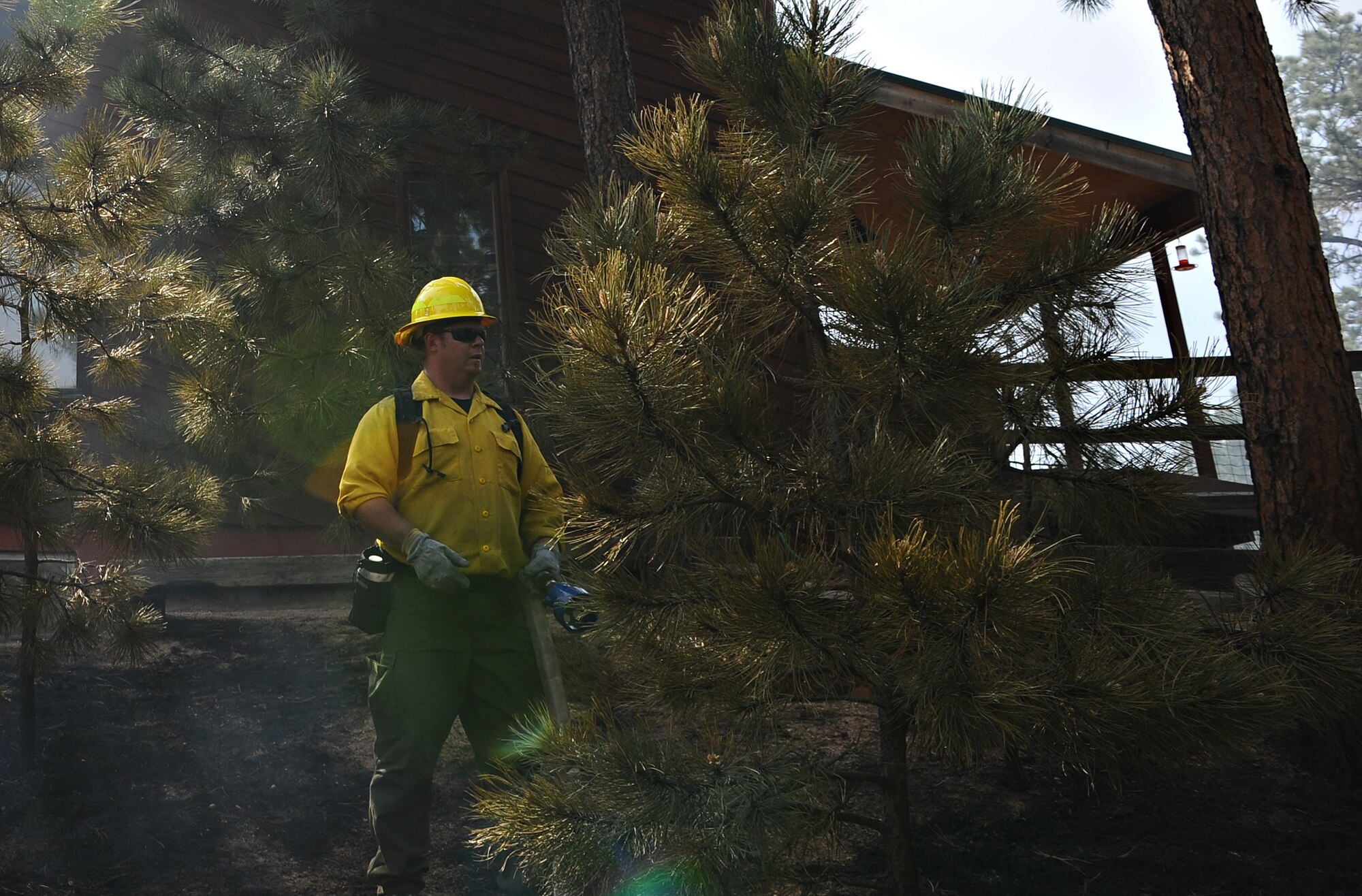 An Air Force Academy firefighter surveys the scene east of Jeff and Elizabeth Miller's Black Forest home June 13, 2013. The Black Forest Fire encroached on the property, burning most of the Millers' five-acre lot, but did not touch the house thanks to Academy firefighters' efforts. (U.S. Air Force photo/Master Sgt. Christopher DeWitt)