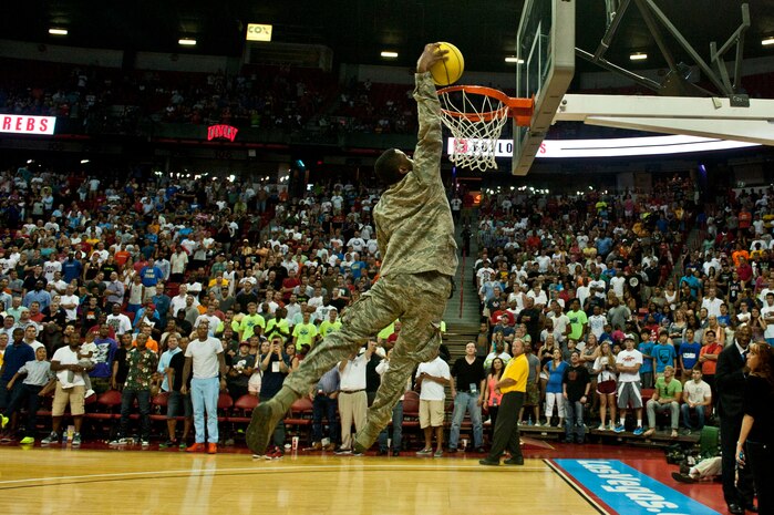 U.S. Air Force Senior Airman Nathaniel Mills, 99th Security Forces Squadron, performs a windmill dunk during a time out during the third quarter of the USA Blue vs. White Basketball game at the Thomas and Mack Center July 25, 2013, in Las Vegas. Mills was asked to dunk during the Airmen’s recognition at the game. He was one of the recently returned Airmen recognized at the game. (U.S. Air Force photo by Senior Airman Daniel Hughes)