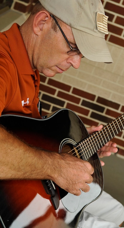 Woody Groton, Fort Eustis Warrior Transition Unit site coordinator for the military adaptive sport program, plays his guitar during the “Music for Morale” program at Fort Eustis, Va., July 11, 2013. Groton started the program as a way to share his love for playing guitar while helping Soldiers in their recovery process. (U.S. Air Force photo by Staff Sgt. Wesley Farnsworth/Released)  