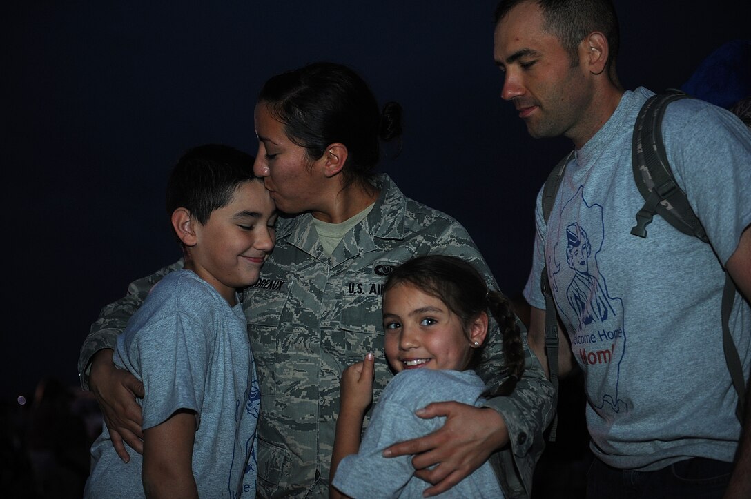 Senior Airman Jory Boudreaux, 28th Operations Support Squadron aircrew flight equipment technician, embraces her children after returning from a deployment during a welcome-home event at the Pride Hangar on Ellsworth Air Force Base, S.D., July 26, 2013. Boudreaux was one of approximately 400 Airmen who deployed to Southwest Asia in January where the Airmen supported national military objectives in the U.S. Central Command area of responsibility. (U.S. Air Force photo by Airman 1st Class Rebecca Imwalle/Released)