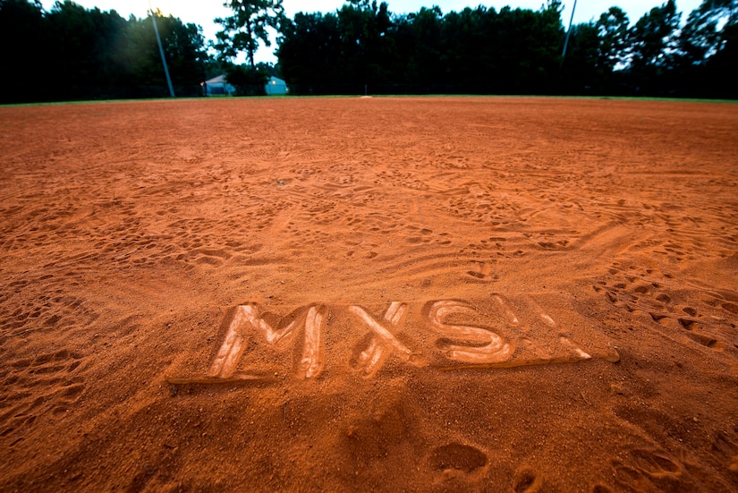 Members from the 437th Maintenance Squadron draw “MXS!!” on the pitcher’s mound after winning the Intramural Softball Base Championship July 24, 2013, at Joint Base Charleston – Air Base, S.C. 437th MXS defeated the 628th Security Forces Squadron 14 – 11 in the championship game. (U.S. Air Force photo/ Senior Airman George Goslin)