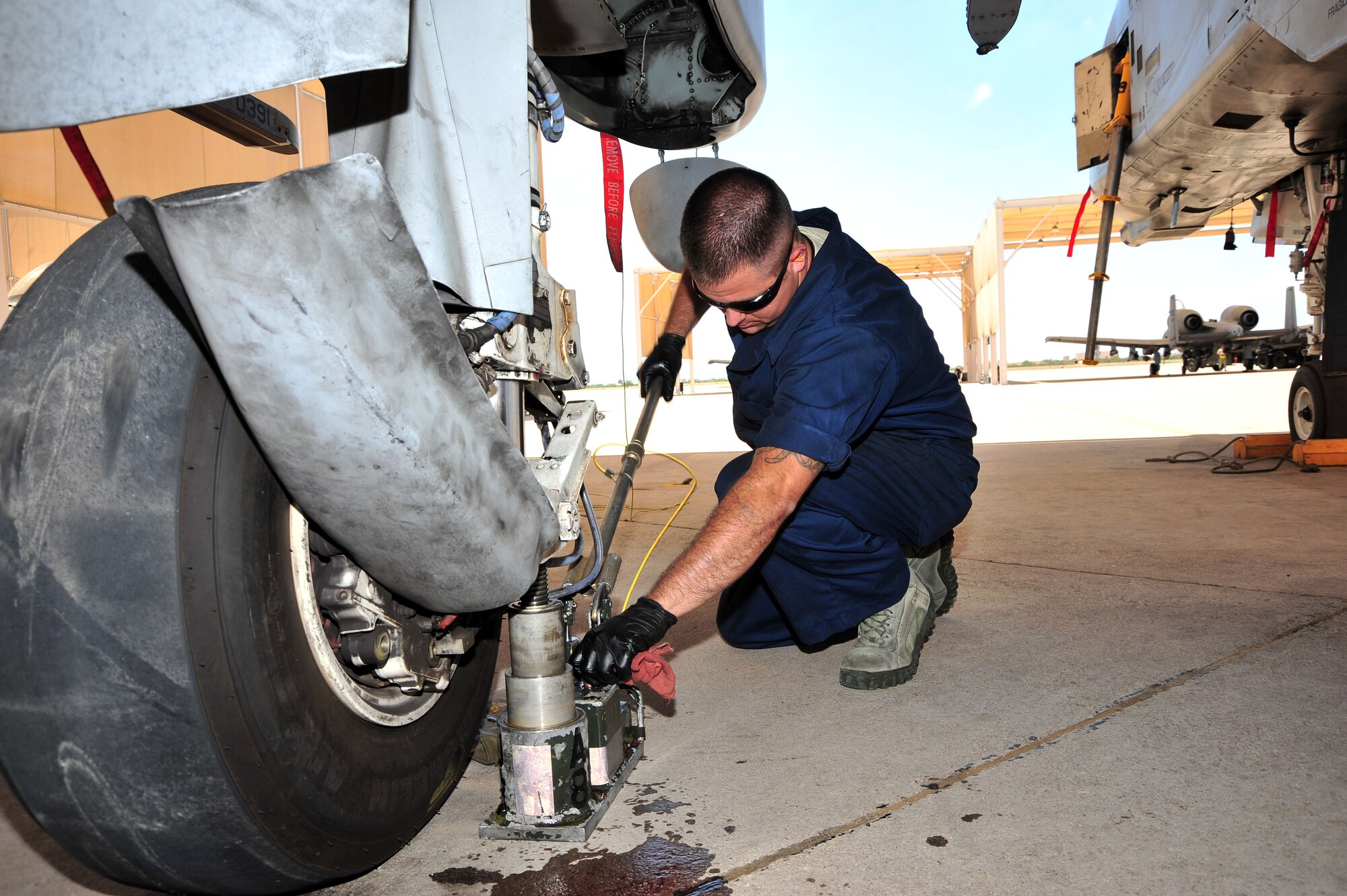 U.S. Air Force Staff Sgt. Richard Baca, 924th Maintenance Squadron A-10 crew chief, uses an axel jack to replace a tire at Davis-Monthan Air Force Base, Ariz., July 23, 2013. Baca is a reservist working with the 355th Aircraft Maintenance Squadron.(U.S. Air Force Photo by Airman 1st Class Josh Slavin) 