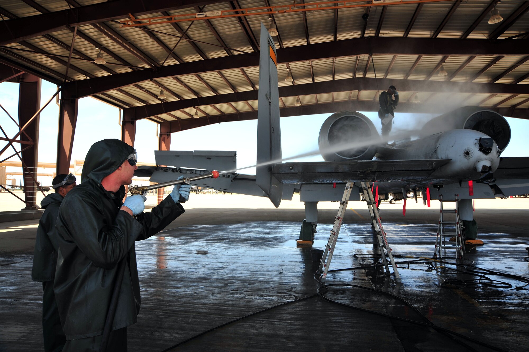 U.S. Air Force Airman 1st Class FIRST Raettig, 355th Aircraft Maintenance Squadron avionics specialist, uses a pressure washer to clean an A-10 Warthog at Davis-Monthan Air Force Base, Ariz., July 23, 2013. The 355th AMXS provides safe, properly configured aircraft in order to meet the flying-hour program for three fighter squadrons.(U.S. Air Force Photo by Airman 1st Class Josh Slavin/Released)