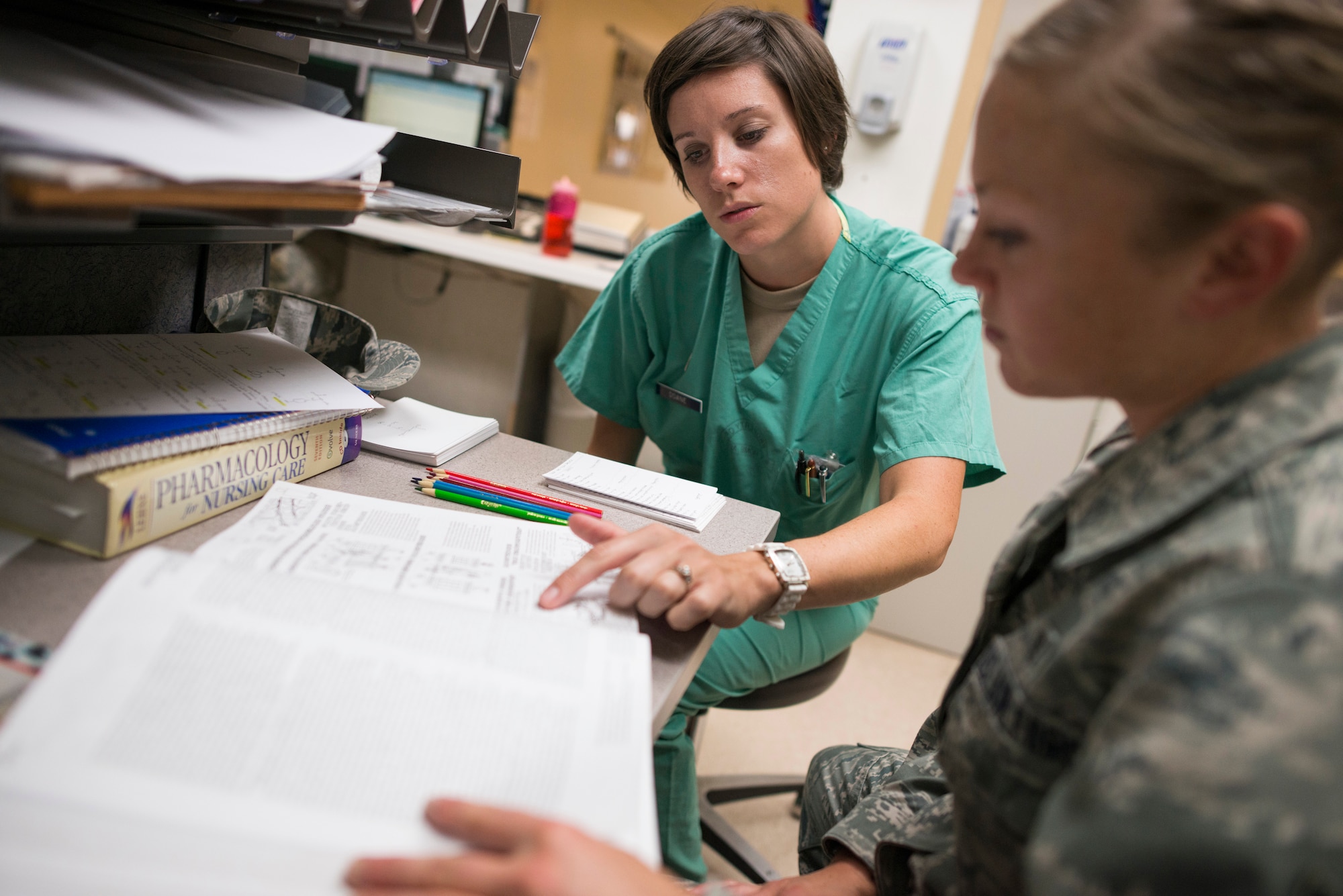 U.S. Air Force 1st Lt. Stephanie Doane, 366th Medical Operations Squadron nurse, explains medical information to Senior Airman Megan Stanton, 366th MDOS medic, in the urgent care center at Mountain Home Air Force Base, Idaho, July 15, 2013. After Stanton's acceptance into the Air Force's physician's assistant program, doctors and nurses in the UCC have helped prepare Stanton for the challenges she will face in school. (U.S. Air Force photo/Tech. Sgt. Samuel Morse)