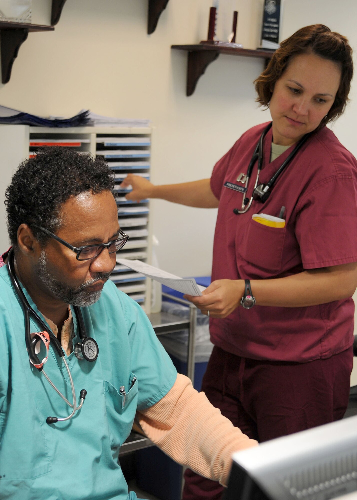 779th Medical Operations Squadron Nurses Walter Cook and Capt. Denise Frederiksen  in-process patients at the Malcolm Grow Medical Clinic and Surgery Center Emergent Care Center on Joint Base Andrews, Md. The Air Force Nurse Corps celebrated their 64th Birthday on July 1, 2013. (U.S. Air Force photo Tech. Sgt. Tammie Moore)