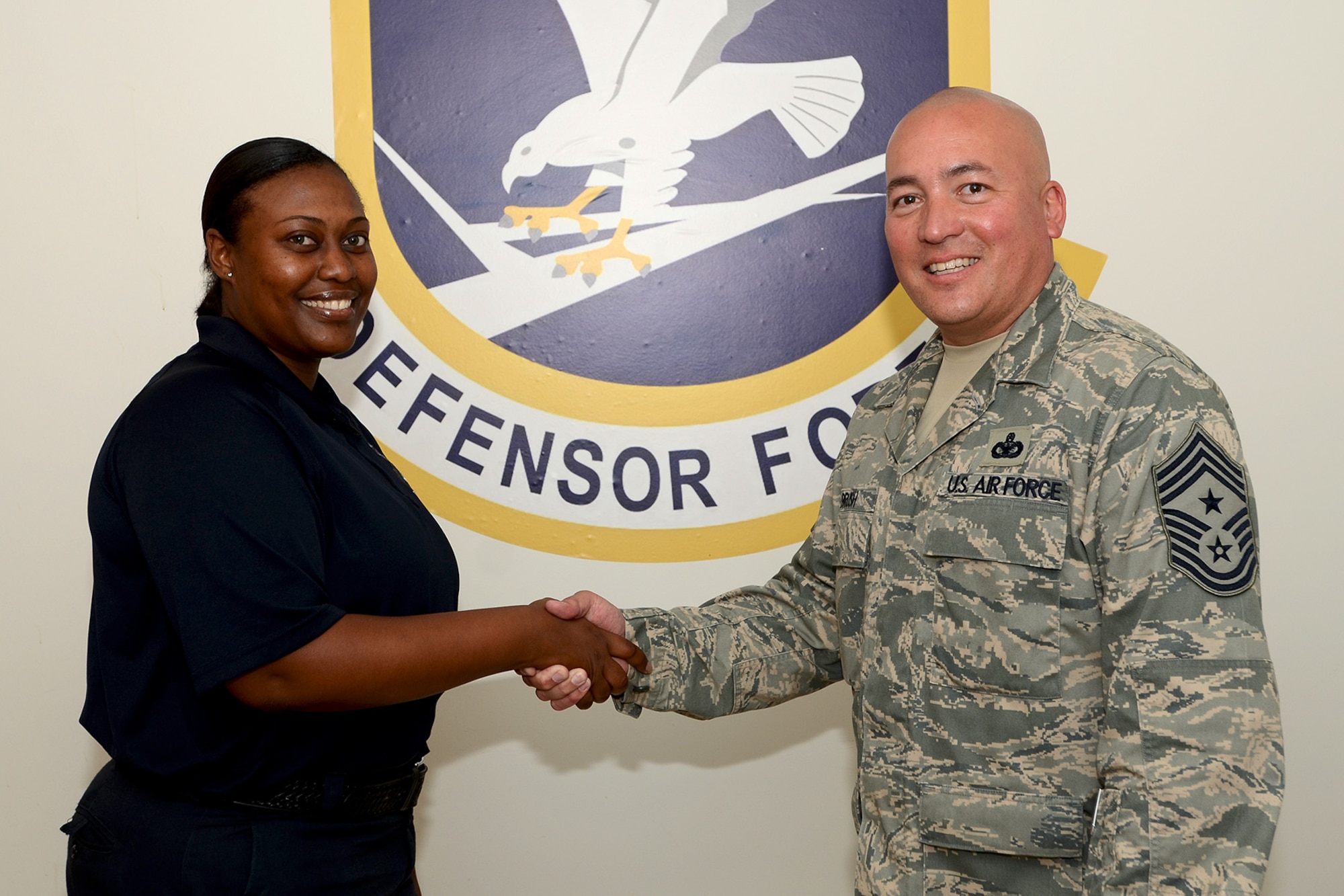 U.S. Air Force Command Chief Master Sgt. Mitchell Brush, Senior Enlisted Advisor to the Chief of the National Guard, National Guard Bureau, Washington D.C., presents Ms. Veronica Dennis, 169th Security Forces Squadron, with a coin for her outstanding work in the unit during his visit with the 169th Fighter Wing, South Carolina Air National Guard at McEntire Joint National Guard Base, S.C., June 17, 2013.  (U.S. Air National Guard photo by Tech. Sgt. Caycee Watson/Released)