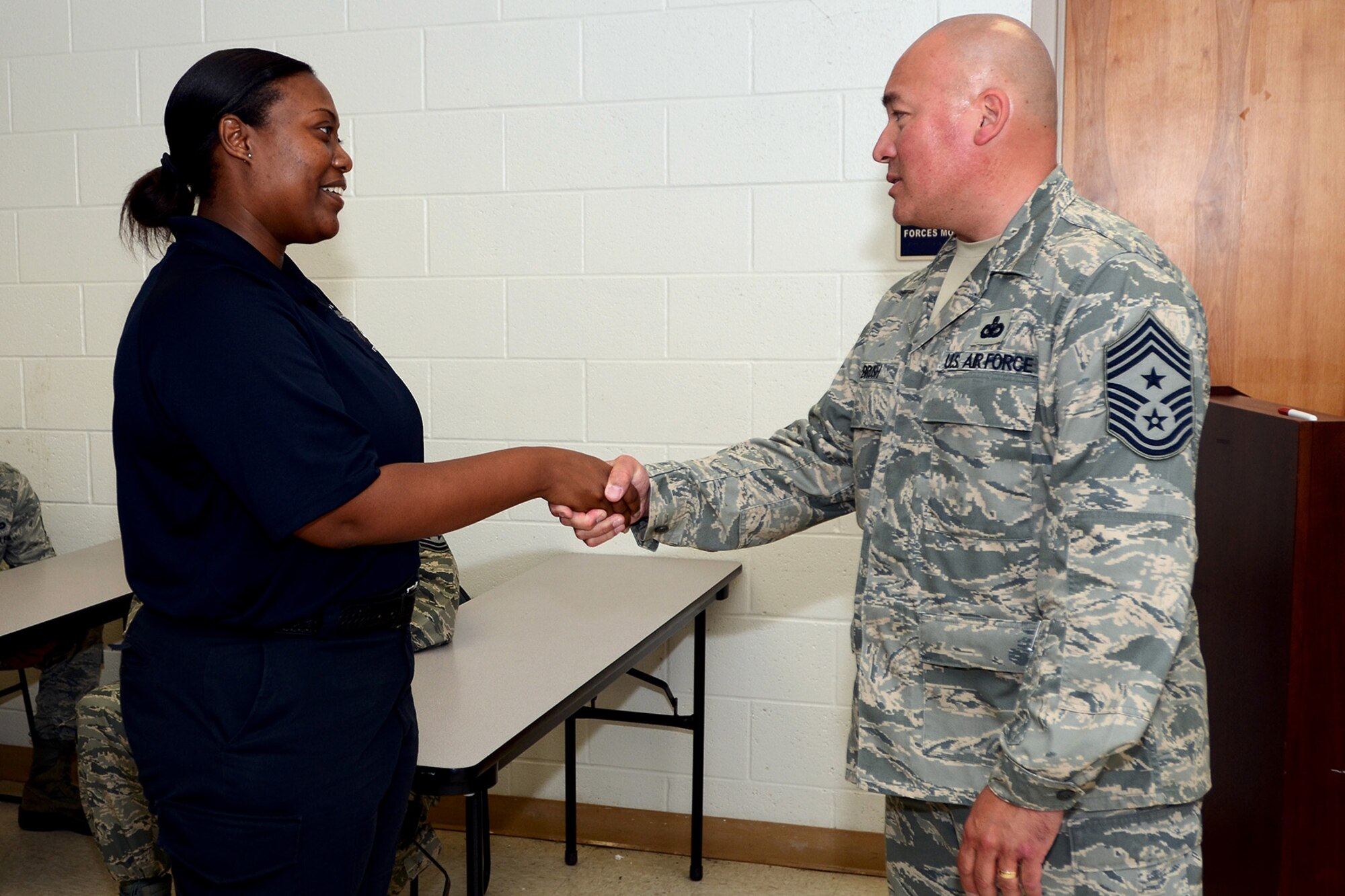 U.S. Air Force Command Chief Master Sgt. Mitchell Brush, Senior Enlisted Advisor to the Chief of the National Guard, National Guard Bureau, Washington D.C., presents Ms. Veronica Dennis, 169th Security Forces Squadron, with a coin for her outstanding work in the unit during his visit with the 169th Fighter Wing, South Carolina Air National Guard at McEntire Joint National Guard Base, S.C., June 17, 2013.  (U.S. Air National Guard photo by Tech. Sgt. Caycee Watson/Released)