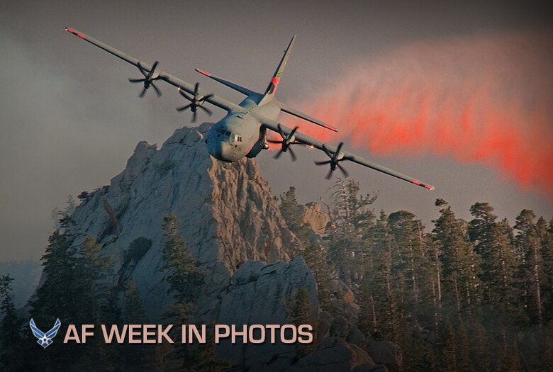 A C-130 Hercules aircraft releases fire retardant over the trees in the mountains above Palm Springs, Calif., July 19, 2013. The unit was activated to assist the community with wildfires. The C-130 Hercules is assigned to the 146th Airlift Wing, California Air National Guard. (U.S. Air National Guard photo/Senior Airman Nicholas Carzis)