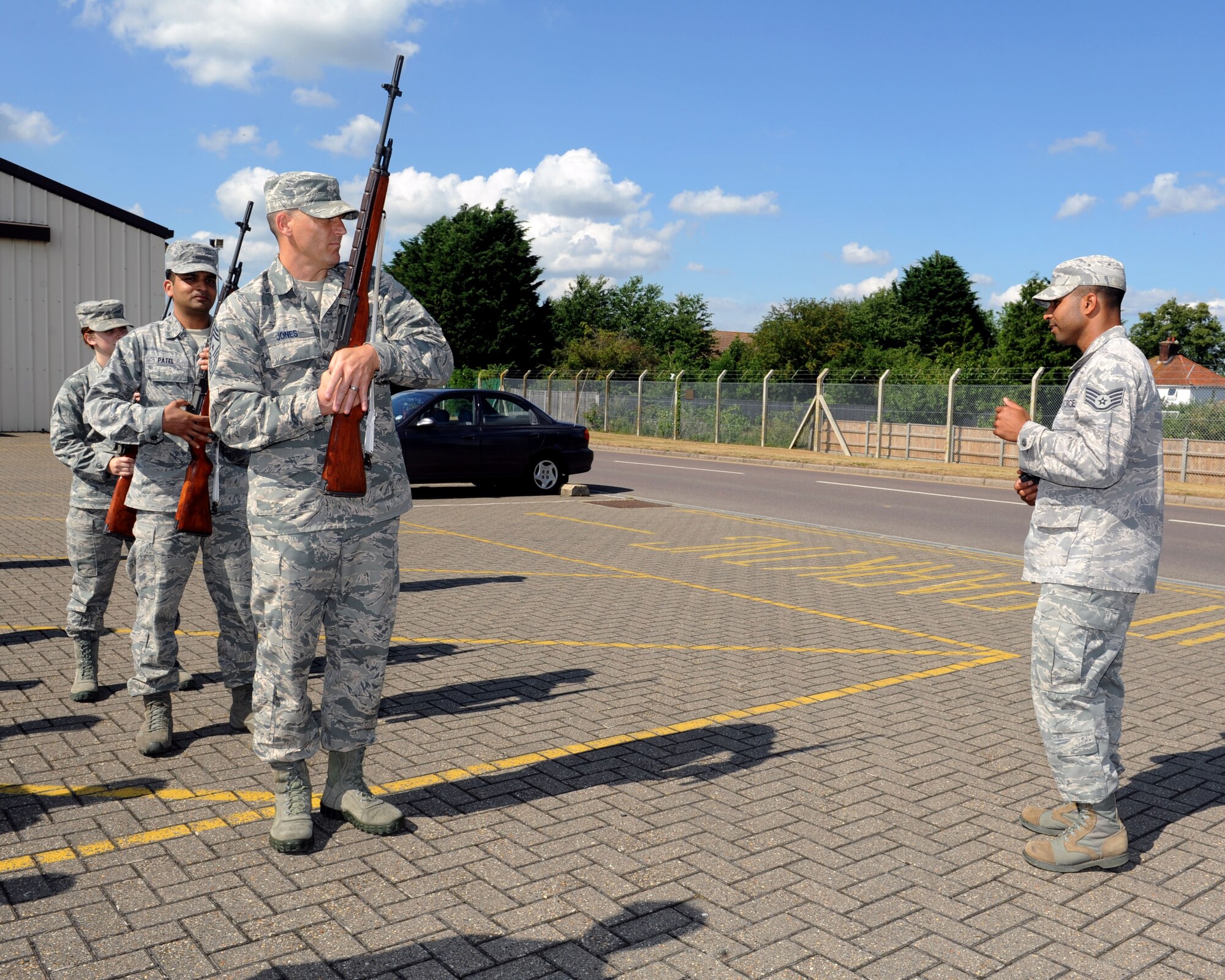 From right, Staff Sgt. Emmanuel Santillan, 100th Force Support Squadron NCO in charge of Honor Guard from the Dominican Republic, explains safety and firing procedures to Chief Master Sgt. Tracy Jones, 100th Air Refueling Wing command chief; Senior Airman Shrutit Patel, 352nd Special Operations Group maintainers analyst from New York, N.Y. and Airman 1st Class Sarah McDermitt, 100th Logistics Readiness Squadron logistics planner from Houston, Texas, before they participate in a firing party July 24, 2013, on RAF Mildenhall, England. Jones attended an honor guard practice to get a glimpse of the hard work and dedication that makes up the Team Mildenhall Honor Guard.  His visit was part of the “Dirty Jobs” program, which enables base leadership to experience the work Airmen do to make the RAF Mildenhall mission possible. (U.S. Air Force photo by Airman 1st Class Preston Webb/Released)