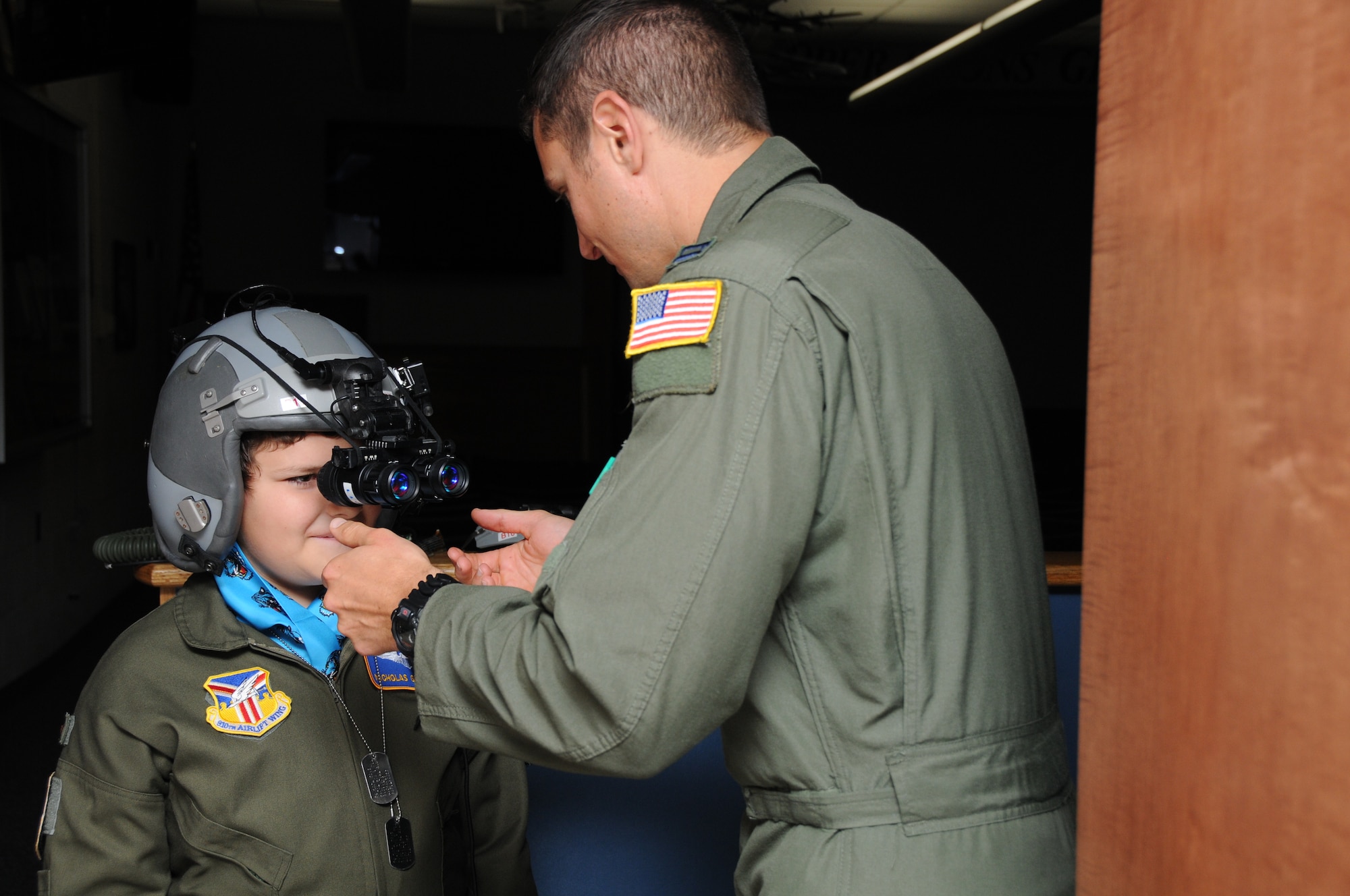YOUNGSTOWN AIR RESERVE STATION, Ohio -- The 910th Airlift Wing's 54th Pilot for a Day, honorary 2nd Lieutenant Nicholas Greathouse, tries on night vision goggles with the assistance of Air Force Reserve Capt. Adam Schubel, a pilot with the 773rd Airlift Squadron, here, July 24. Pilot for a Day is a community outreach program that works through Akron Children's Hospital Boardman to welcome children with chronic or life-threatening illnesses to the station for a day of military experiences. U.S. Air Force photo by SrA Rachel Kocin.