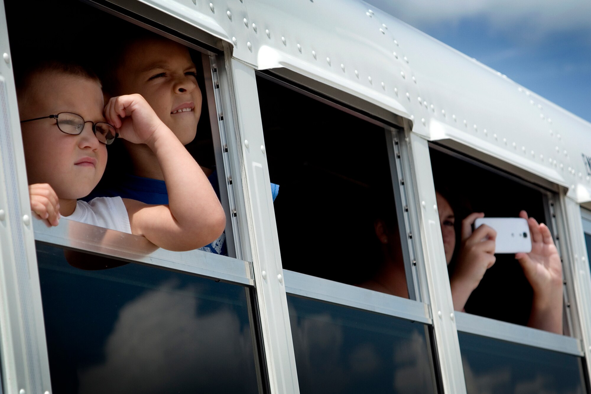 Family members peer out the window of an Air Force bus July 21, 2013, as a KC-135R Stratotanker taxis into the parking ramp at Grissom Air Reserve Base, Ind., bringing loved ones home. Aircrew members returned to Grissom that day following a rotation to Southwest Asia, and they were greeted by family and friends upon their arrival. (U.S. Air Force photo/Tech. Sgt. Douglas Hays)