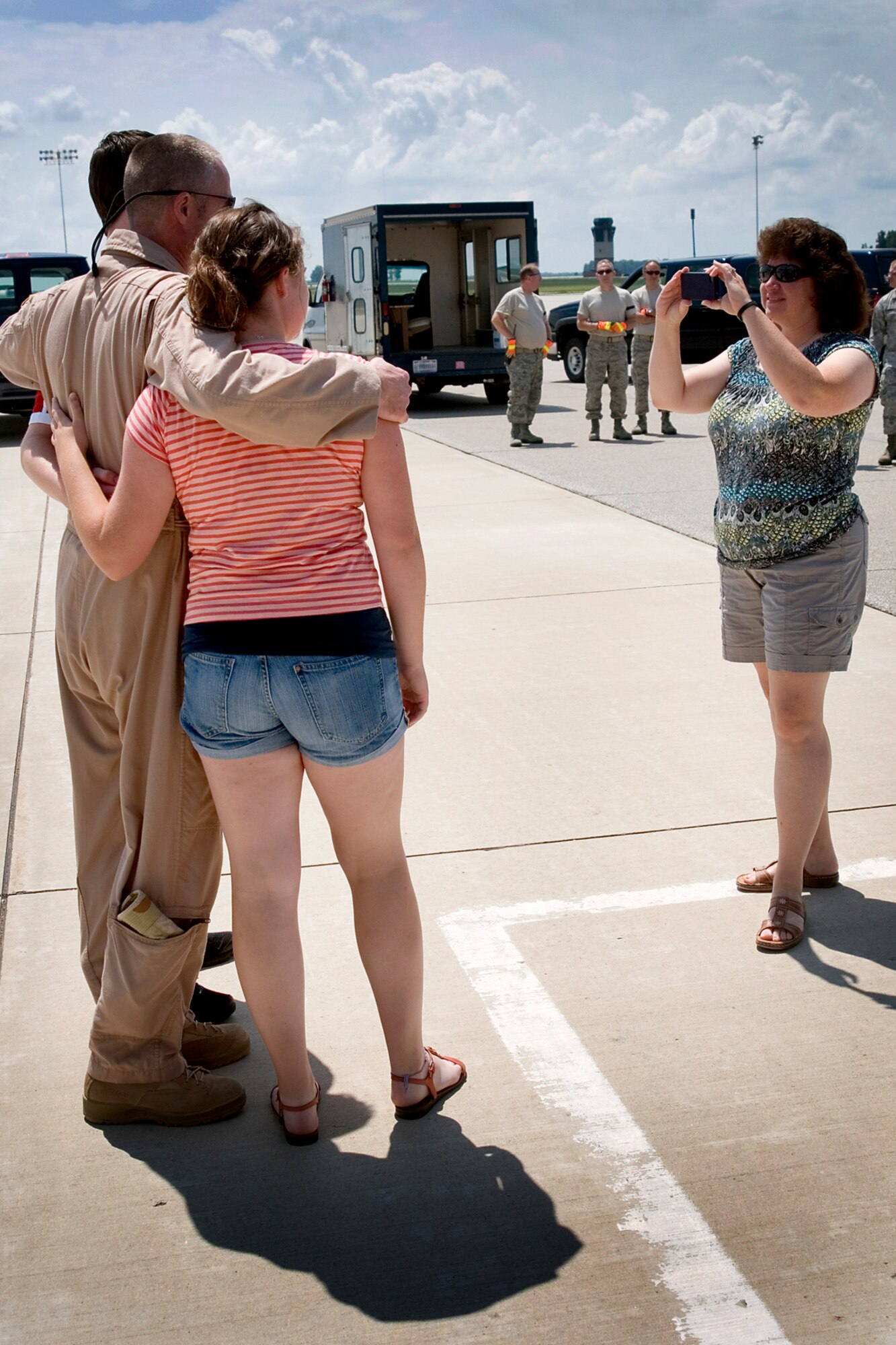 Dawn Thibault, wife of Lt. Col. Todd Thibault, 434th Operations Squadron chief of scheduling, takes a photo of him with their son Michael and daughter Mackenzie after landing at Grissom Air Reserve Base, Ind., July 21, 2013. Thibault and other aircrew members returned to Grissom that day following a deployment to Southwest Asia. (U.S. Air Force photo/Tech. Sgt. Douglas Hays)
