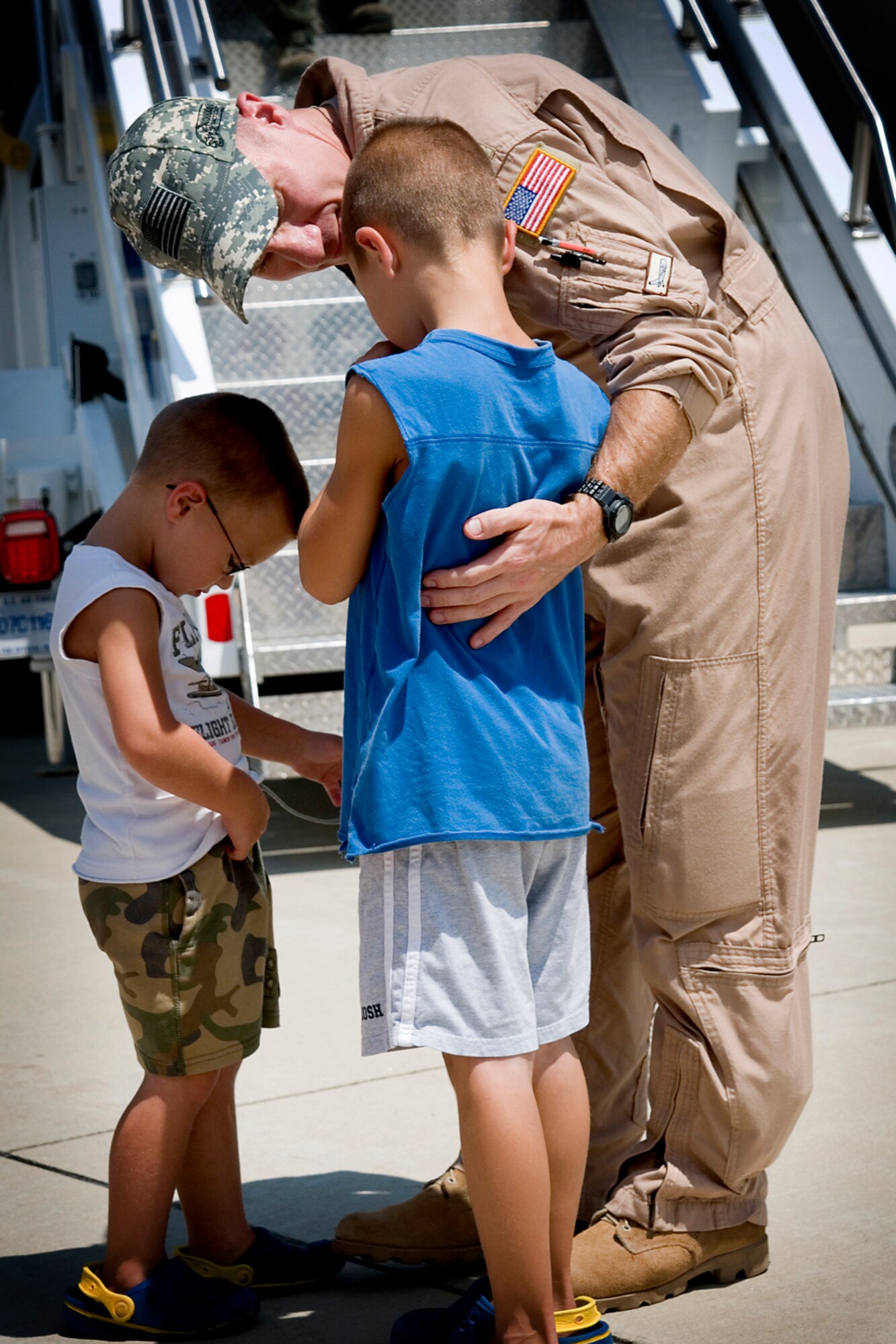 Maj. Dan Keeney, 74th Air Refueling Squadron KC-135R Stratotanker pilot, talks to his sons Jonathan, right, and Daniel, upon his return to Grissom Air Reserve Base, Ind., following a deployment to Southwest Asia.  Keeney and other aircrew members returned to Grissom July 21, 2013. (U.S. Air Force photo/Tech. Sgt. Douglas Hays)