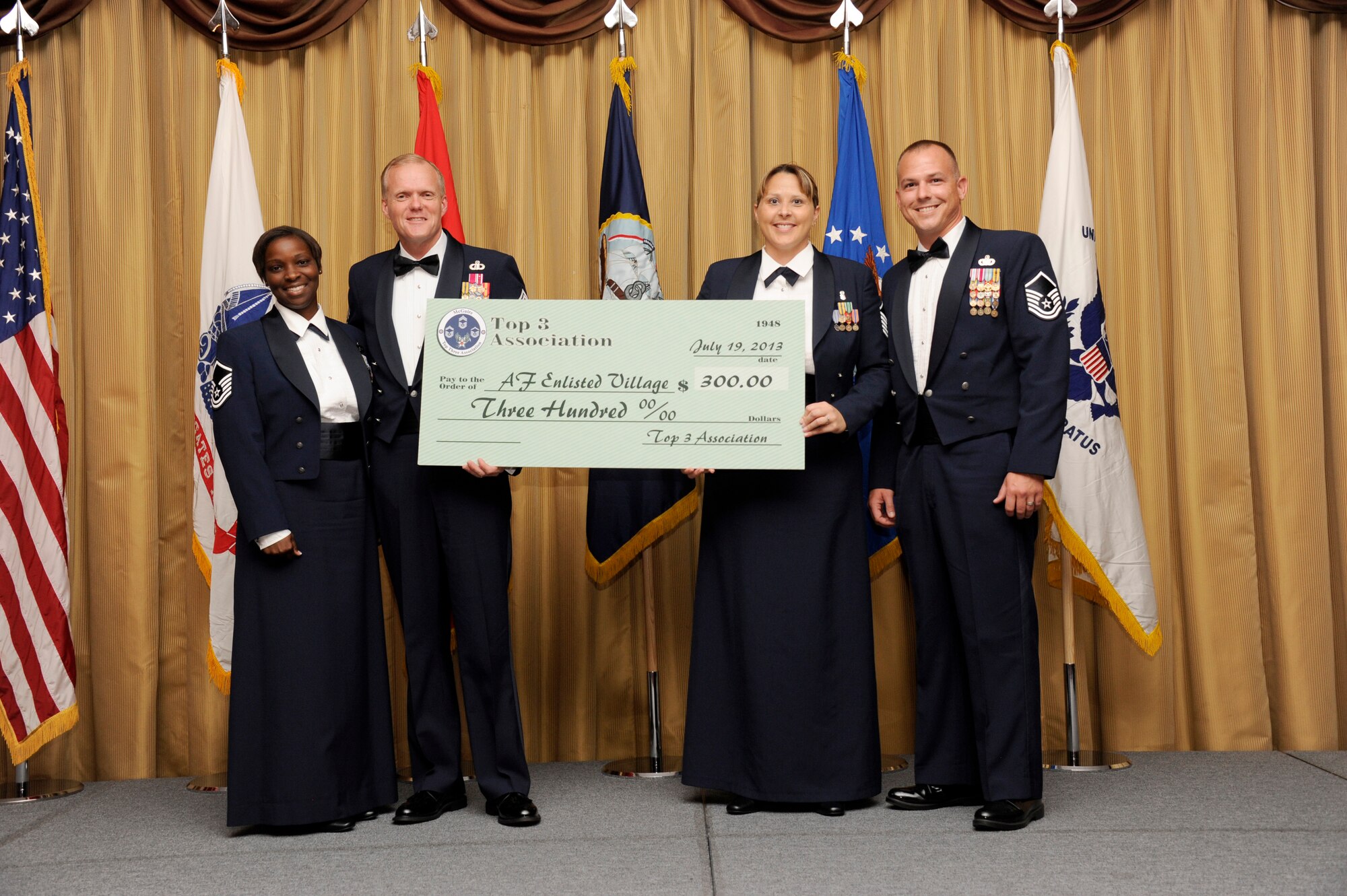 Representatives of the Top 3 Association present Chief Master Sgt. of the Air Force James Cody with a check for $300 toward the Air Force Enlisted Village at the annual Senior Noncommissioned Officer Induction Ceremony July 19, 2013, at the Tommy B. McGuire Community Center on Joint Base McGuire-Dix-Lakehurst, N.J. The chief addressed the group of 75 master sergeant selects and their families at the induction and spent the better part of the day speaking to the Airmen on the base and learning their concerns at their level. (U.S. Air Force photo by Airman Tara A. Williamson/Released)
