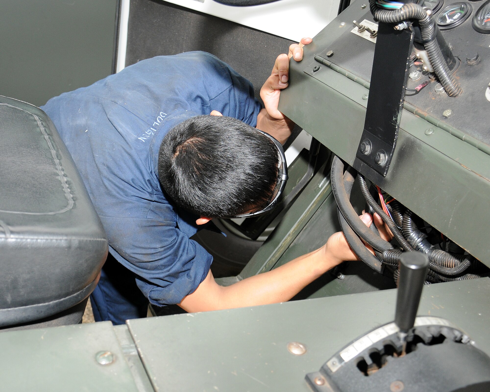 Airman 1st Class James Doligon, 100th Logistics Readiness Squadron vehicle maintainer from Glendale, Calif., conducts a visual inspection of the wiring system and electronic control module of one of the squadron’s newly assigned MB-4 Aircraft Tow Vehicles July 10, 2013, on RAF Mildenhall, England. These types of inspections are completed on all vehicles when the shop receives, ships or deploys them. (U.S. Air Force photo by Gina Randall/Released)