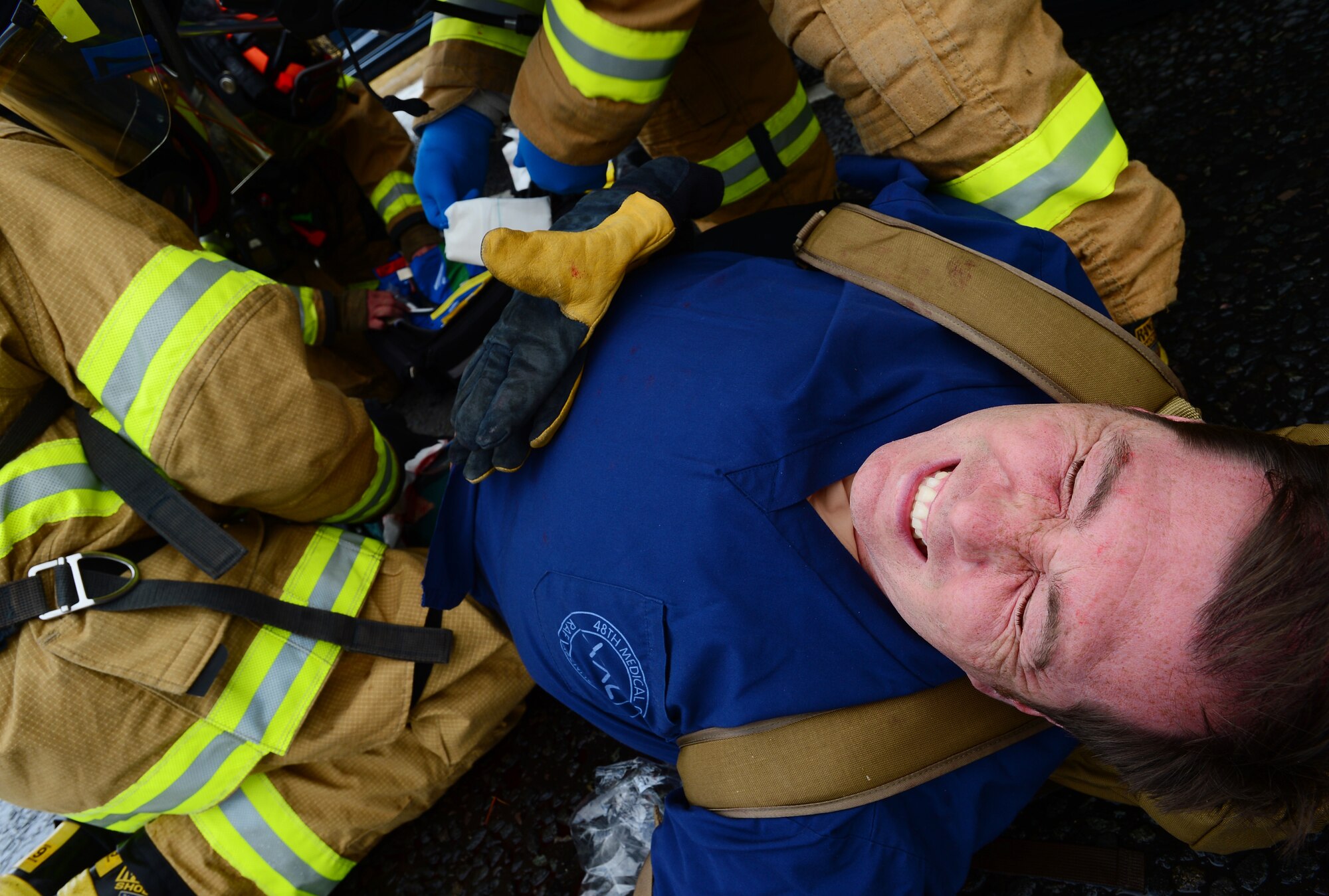 Dave Scott, 48th Medical Group medical simulation coordinator, portrays a victim of a mock car accident as 48th Civil Engineer Squadron firefighters tend to his wounds at Royal Air Force Lakenheath, England, July 25, 2013. Liberty Airmen utilized various exercise scenarios to maintain readiness and increase proficiency and response time. (U.S. Air Force photo by Senior Airman Tiffany M. Grigg) 