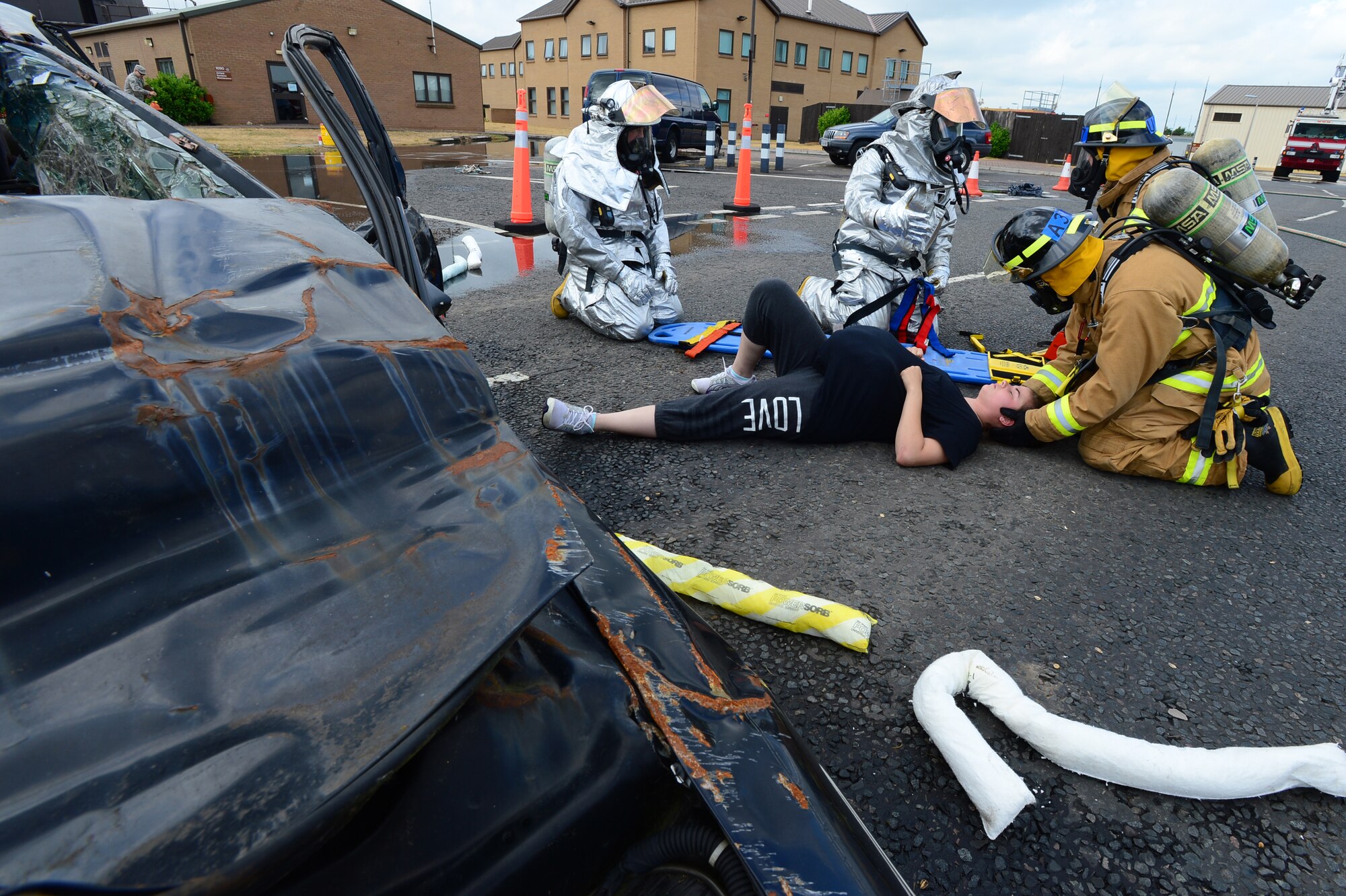 Firefighters from the 48th Civil Engineer Squadron prepare to transport Airman 1st Class Alexandra Burnhisel, 48th Munitions Squadron storage dispatch apprentice, during a mock car accident at Royal Air Force Lakenheath, England, July 25, 2013. Liberty Airmen utilized various exercise scenarios to maintain readiness and increase proficiency and response time. (U.S. Air Force photo by Senior Airman Tiffany M. Grigg) 