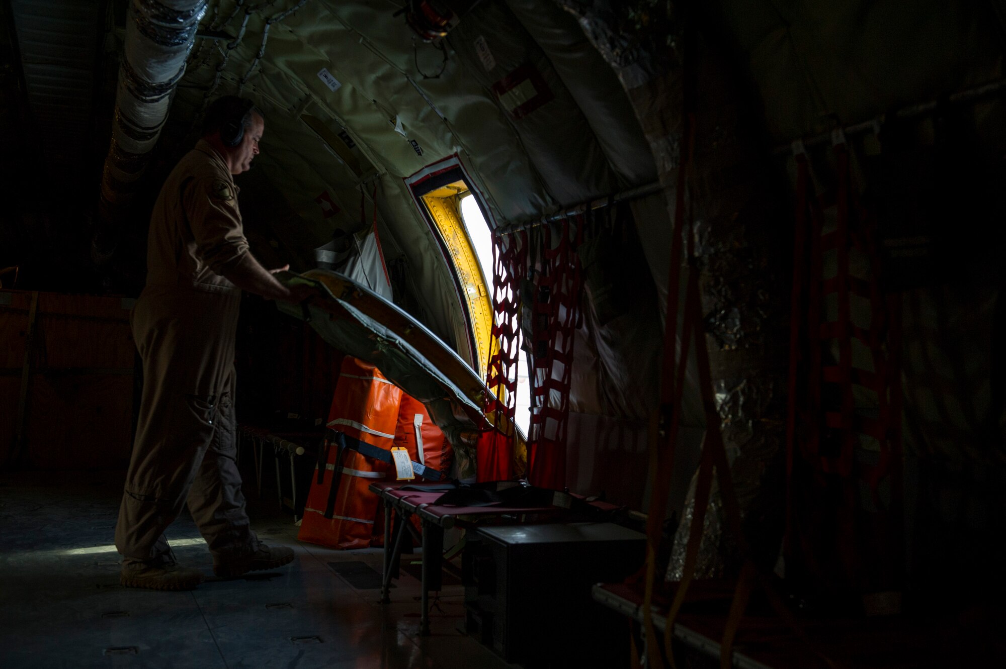 U.S. Air Force Senior Master Sgt. Bill Garrett, 340th Expeditionary Air Refueling Squadron KC-135 Stratotanker boom operator, re-attaches the side doors before taking off on an aerial refueling mission, July 17, 2013, at an undisclosed location in Southwest Asia. Refueling missions here support air operations in and around Afghanistan as part of Operation Enduring Freedom. Garrett, a native of Phoenix, Ariz., is deployed from the Arizona Air National Guard, 161st Air Refueling Wing, Phoenix, Ariz. (U.S. Air Force photo/Staff Sgt. Marleah Miller)