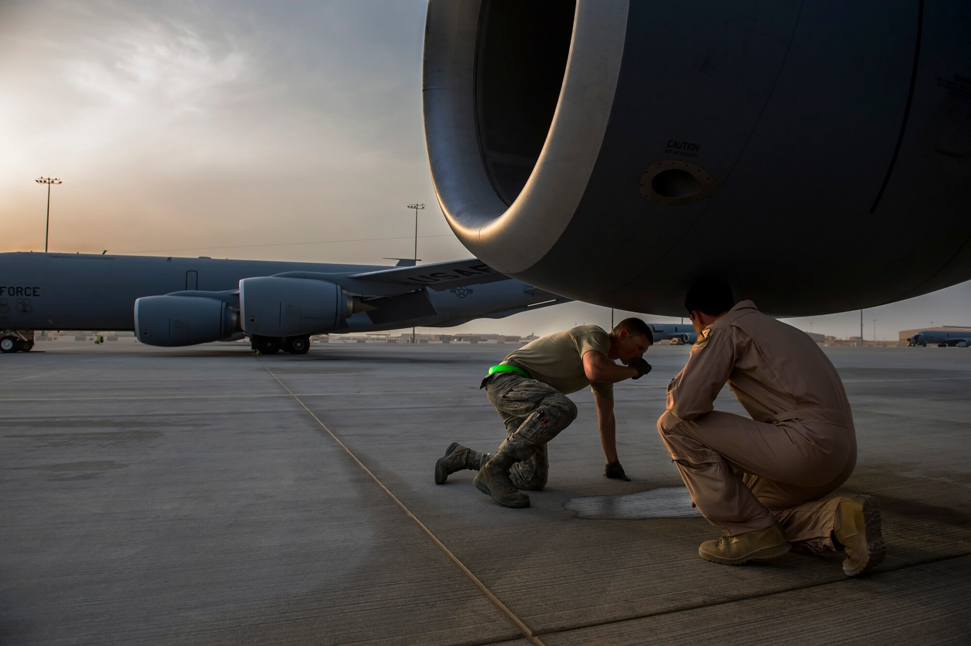 U.S. Air Force Airman 1st Class Travis Porter, left, 379th Expeditionary Air Maintenance Squadron Electrical Environmental, checks a puddle under an engine of a KC-135 Stratotanker, during pre-flight inspections with U.S. Air Force Capt. Neal Hunter, right, 340th Expeditionary Air Refueling Squadron KC-135 Stratotanker pilot, July 17, 2013, at an undisclosed location in Southwest Asia. Refueling missions here support air operations in and around Afghanistan as part of Operation Enduring Freedom. Porter, a native of Couert'Alene, Idaho, is deployed from McConnell Air Force Base, Kan. Hunter, a native of Minnetonka, Minn., is deployed from the Arizona Air National Guard, 161st Air Refueling Wing, Phoenix, Ariz. (U.S. Air Force photo/Staff Sgt. Marleah Miller)