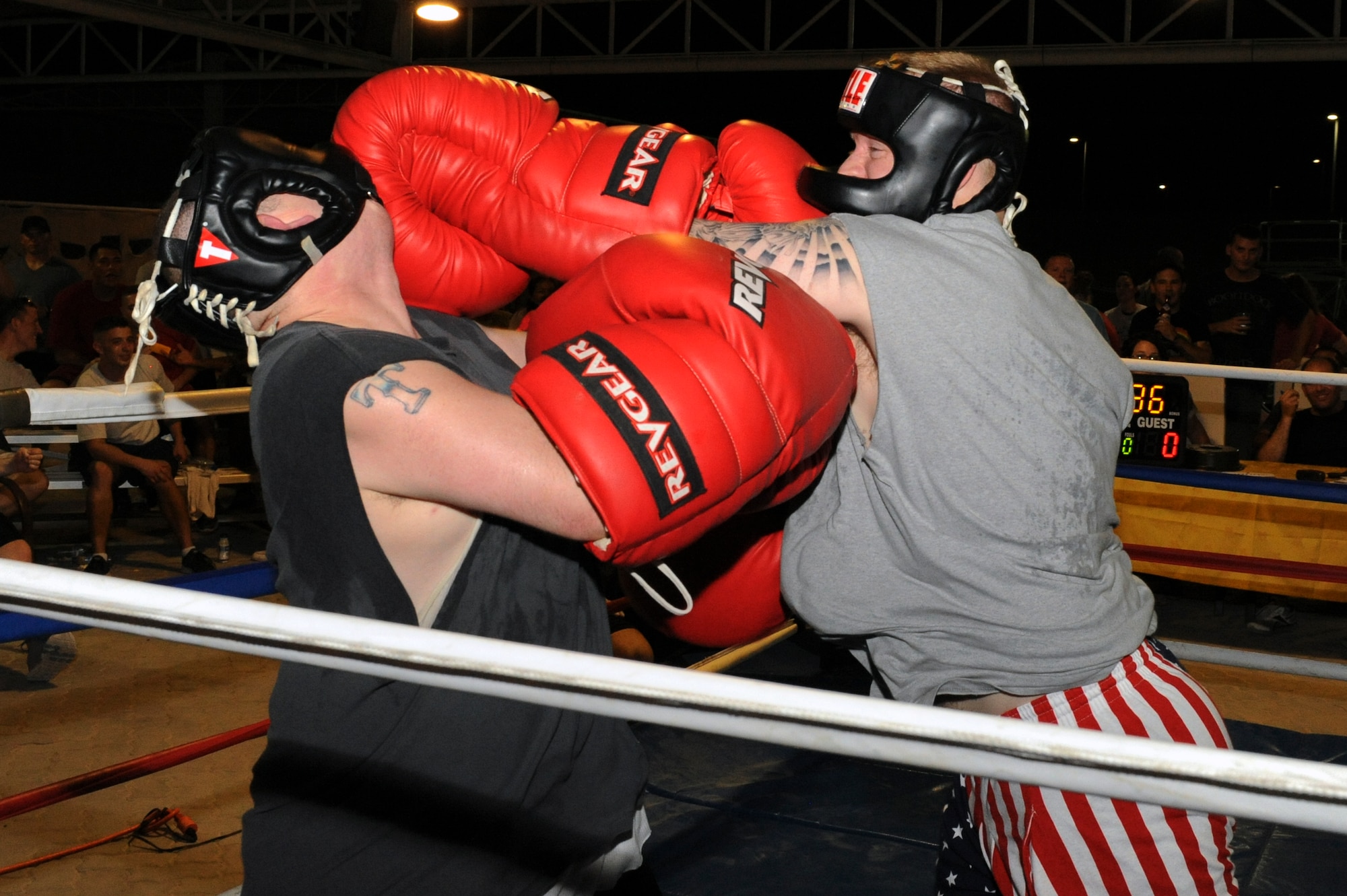 U.S. Airman 1st Class Tyler Cooper, 380th Expeditionary Civil Engineer Squadron, hits U.S. Air Force Staff Sgt. Johnny Collier, 380th ECES, with a haymaker punch during a big glove boxing match at an undisclosed location in Southwest Asia July 19, 2013. Cooper uses the haymaker to render the opponent unable to continue boxing. Cooper is deployed from Eielson Air Force Base, Alaska, and Collier is deployed from Beale Air Force Base, Calif. (U.S. Air Force photo by Staff Sgt. Joshua J. Garcia)